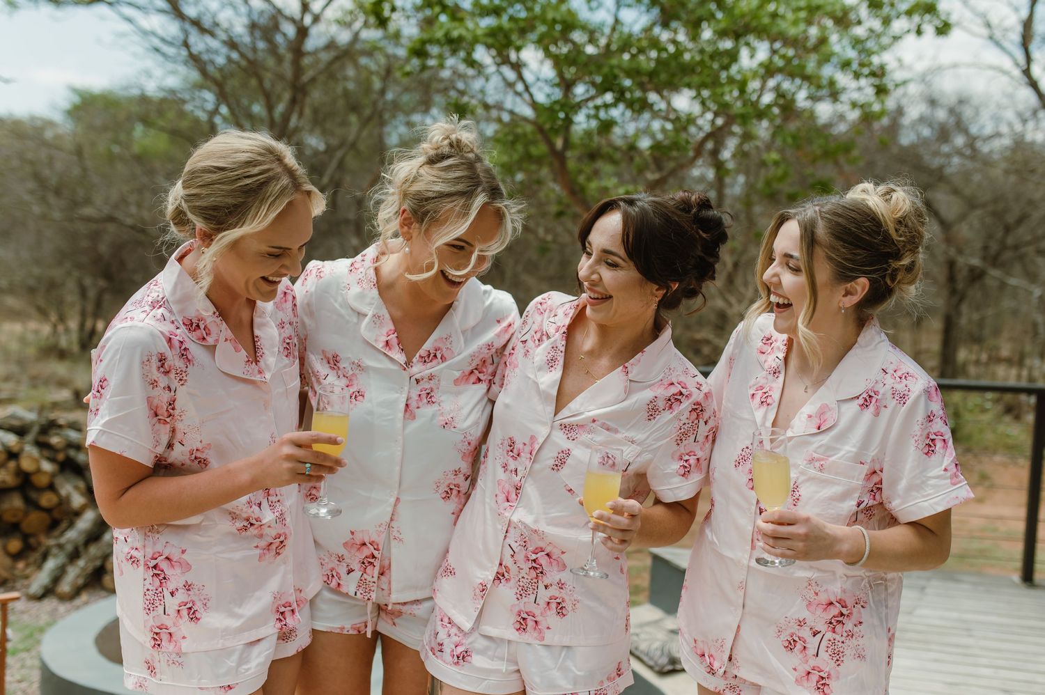 Group wearing matching white and pink floral outfits sitting together outdoors.