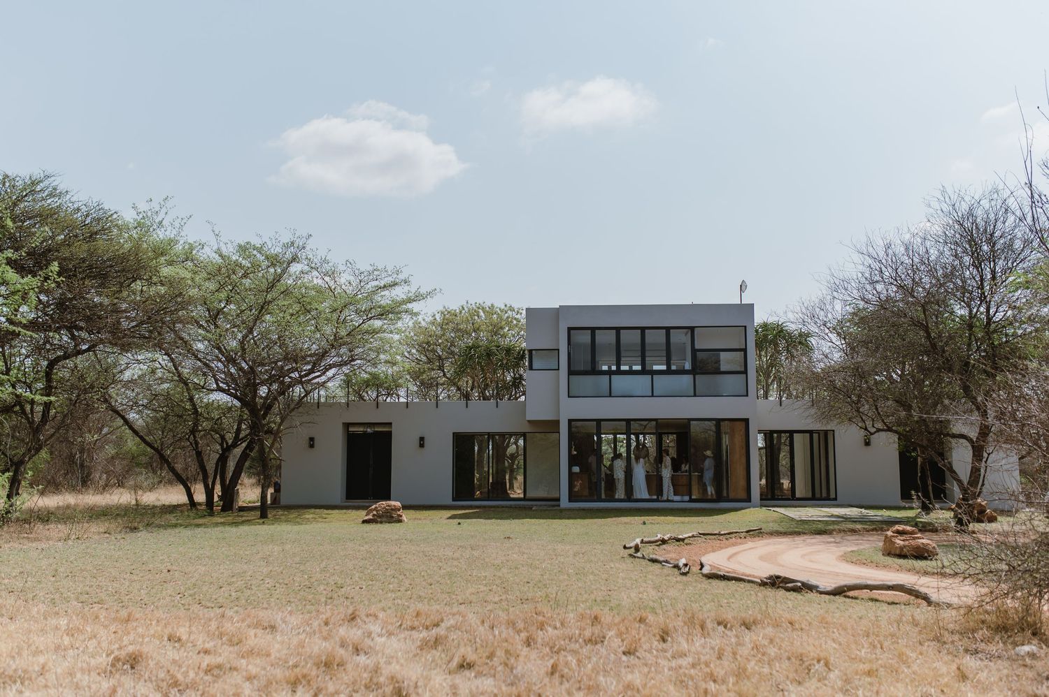 Modern minimalist building exterior with large windows set against an arid landscape.