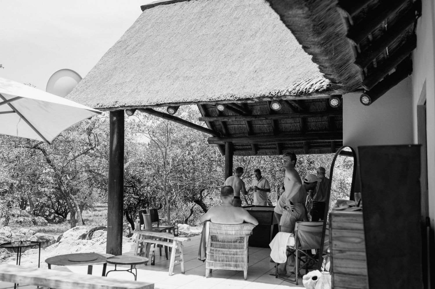 Panoramic view of a mountain lodge with thatched roof and stone walls.