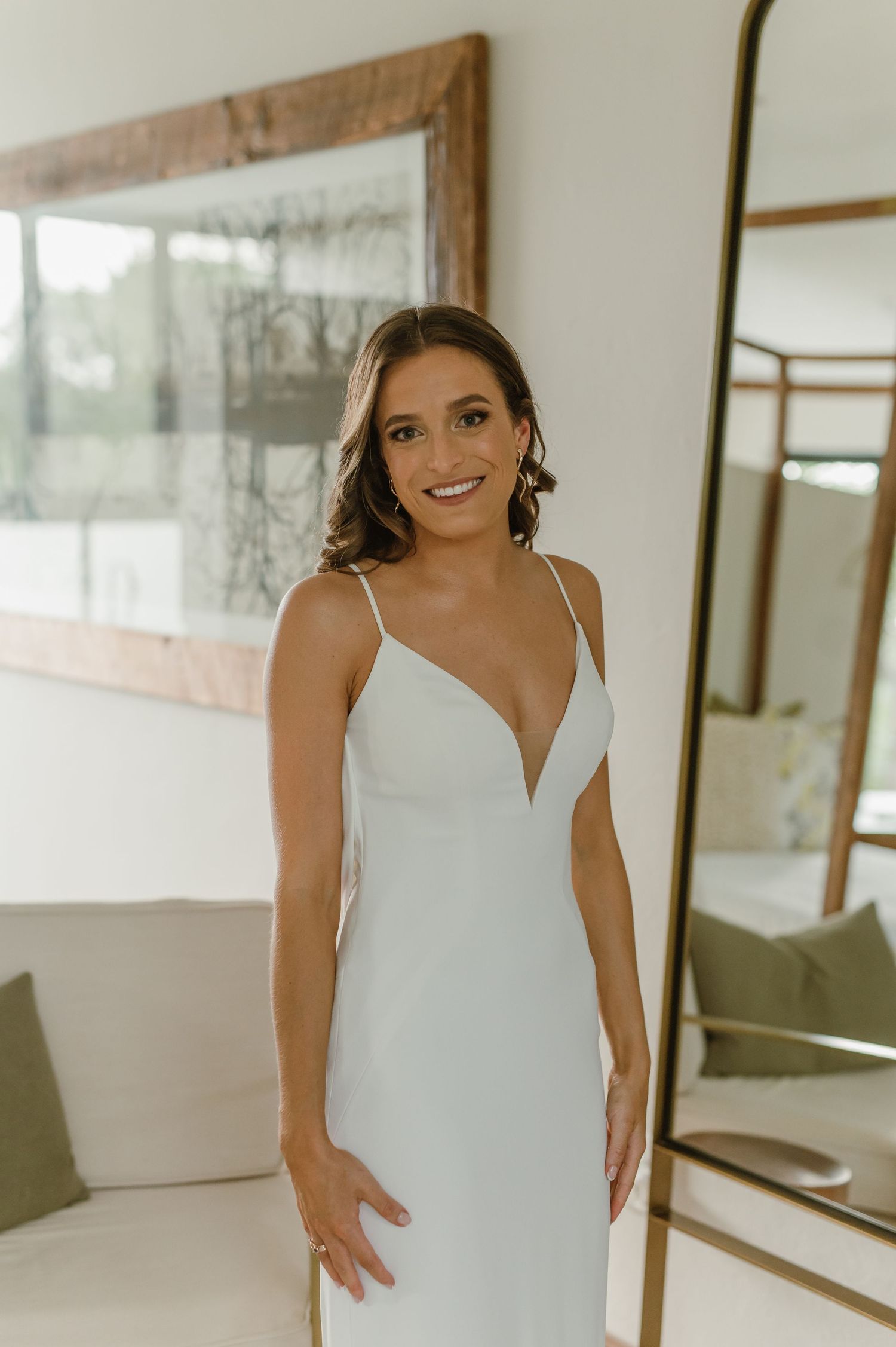 An elegant white wedding dress captured in a modern room with natural decor.