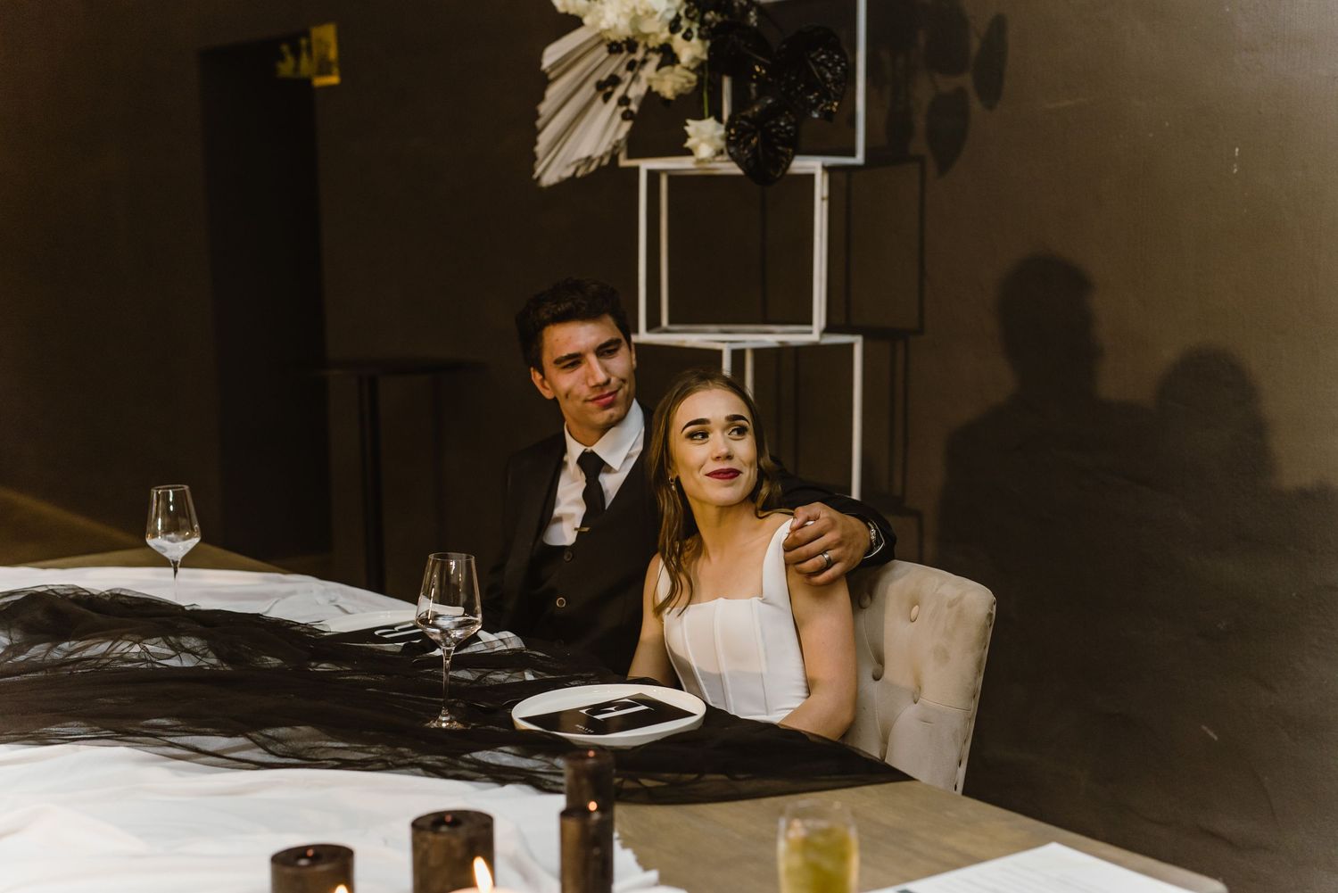 A couple sits at their reception table during an intimate wedding dinner.