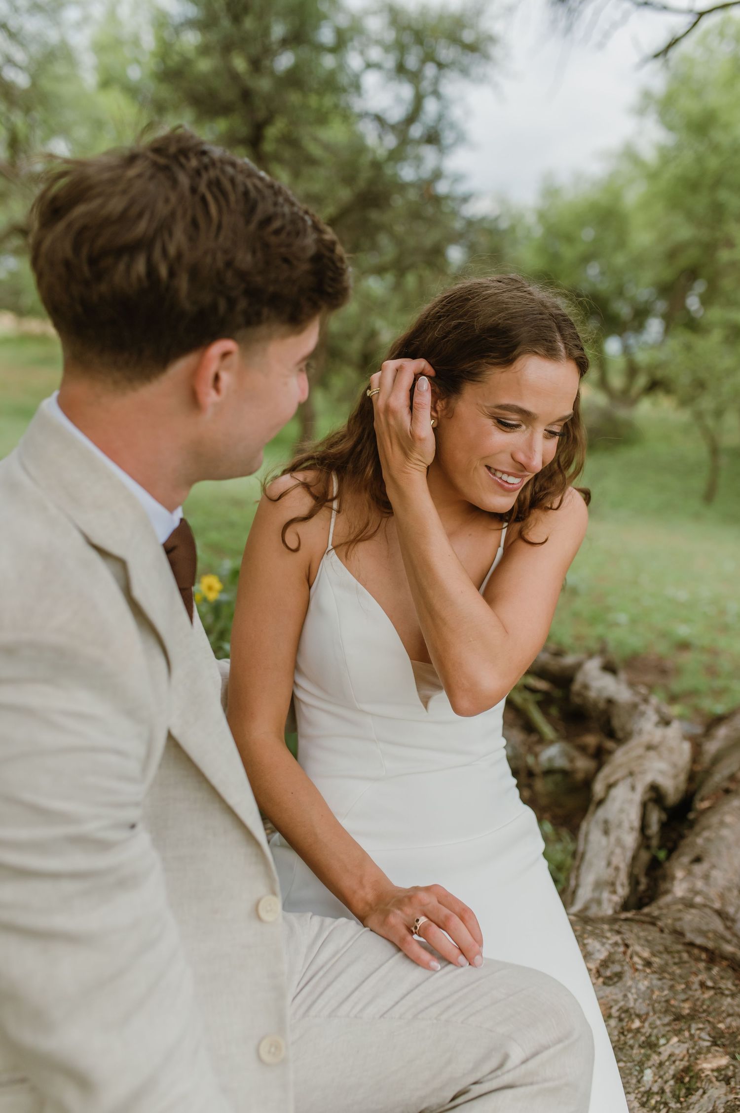 Romantic couple's portrait session on a fallen tree trunk in nature.
