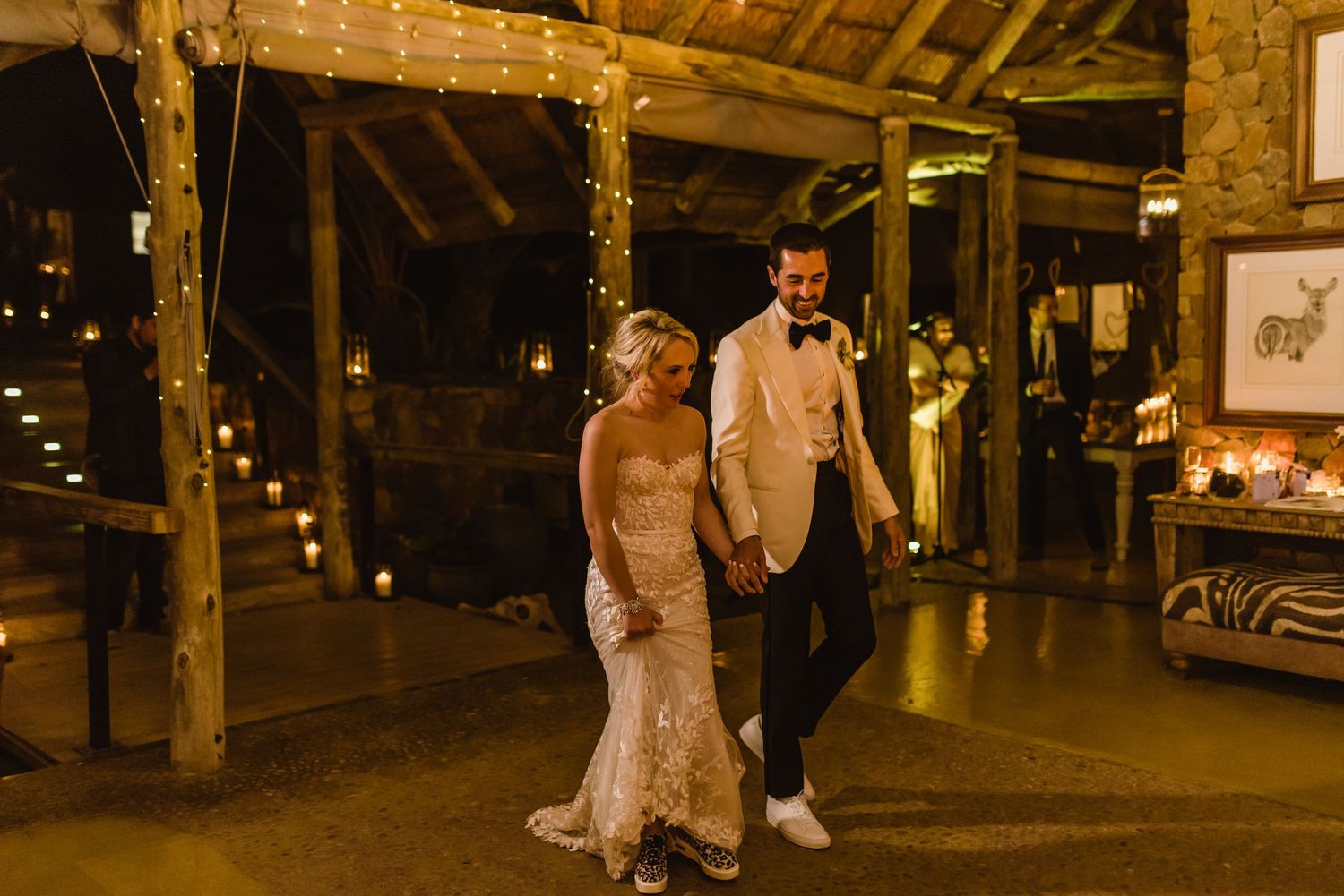 A couple shares a romantic dance in a rustic barn venue illuminated by warm lighting.