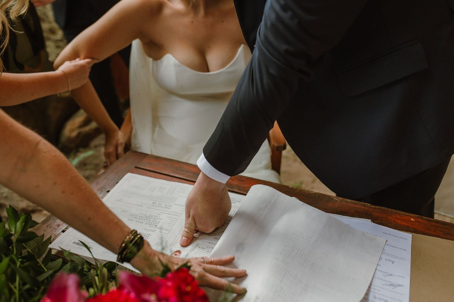 Couple signing their marriage license during an intimate outdoor wedding ceremony.