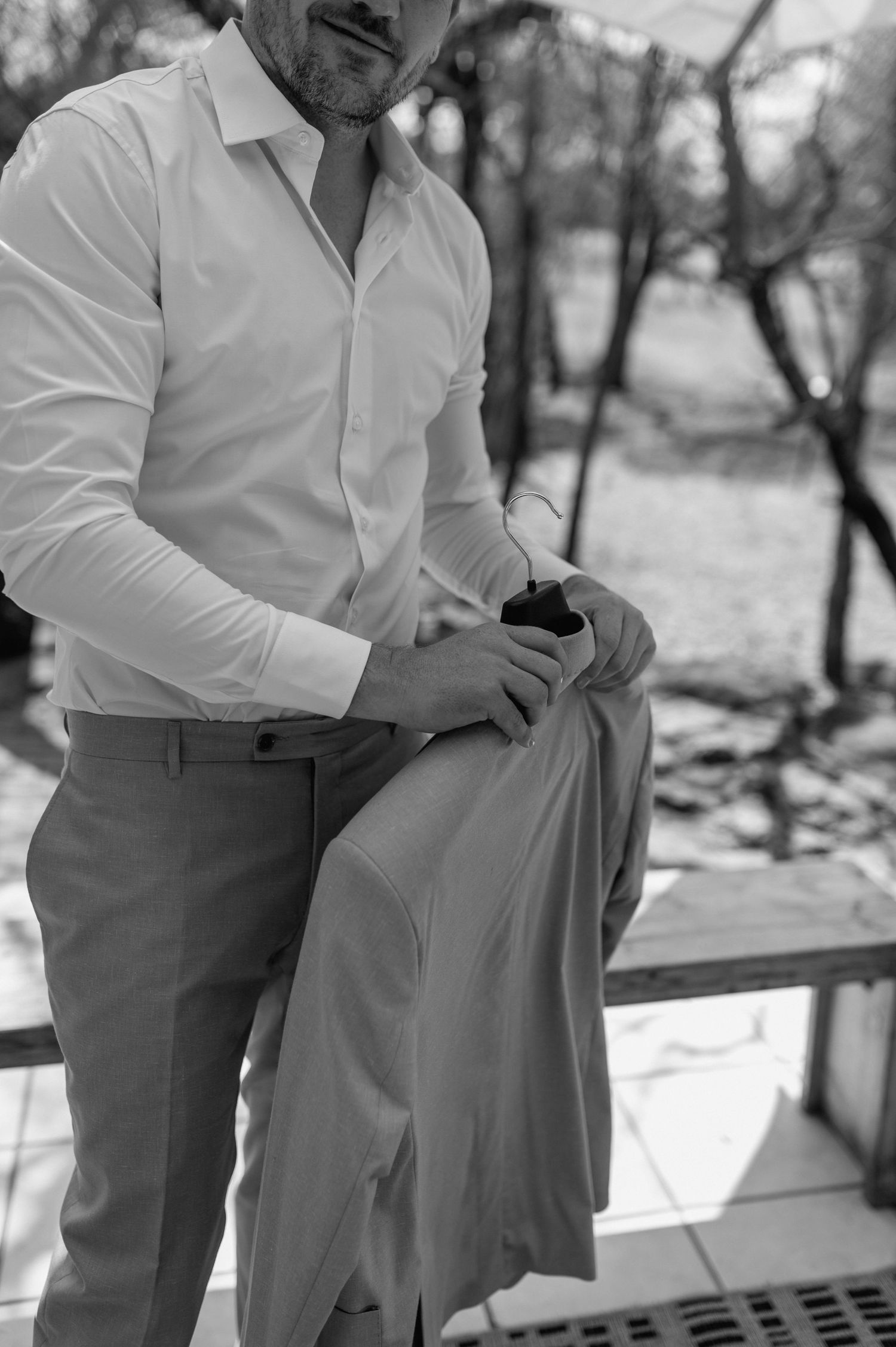 Someone adjusting formal attire while standing outdoors.