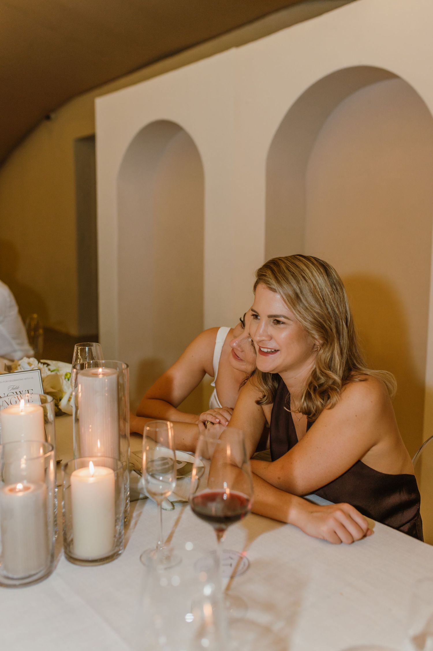 Reception table decorated with white candles and elegant place settings.
