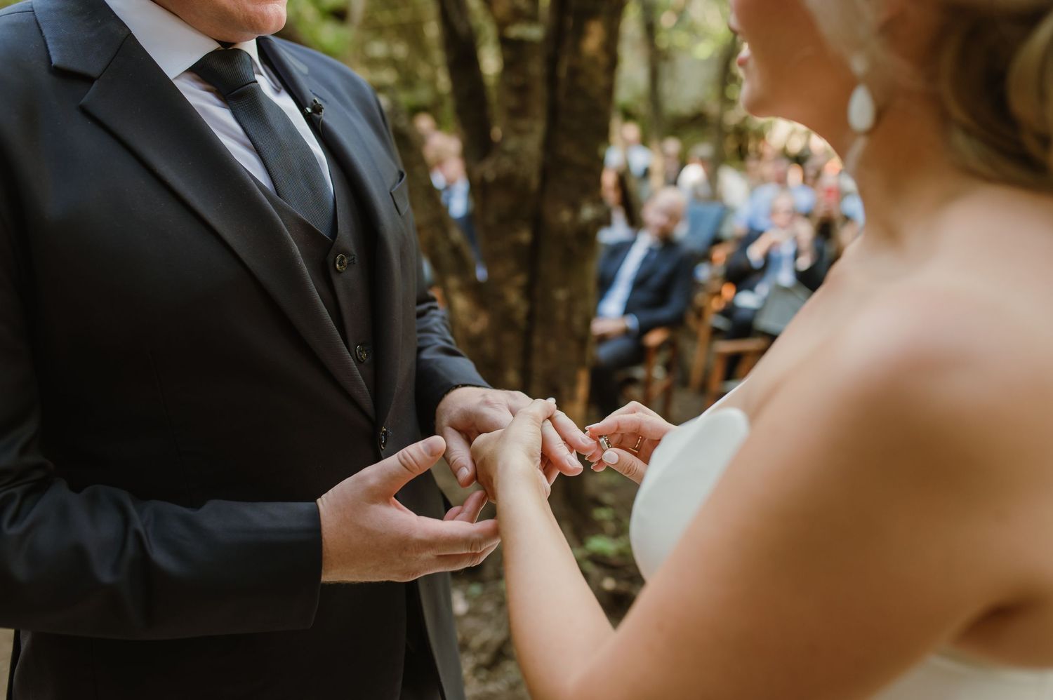 Exchange of rings during an intimate forest wedding ceremony.