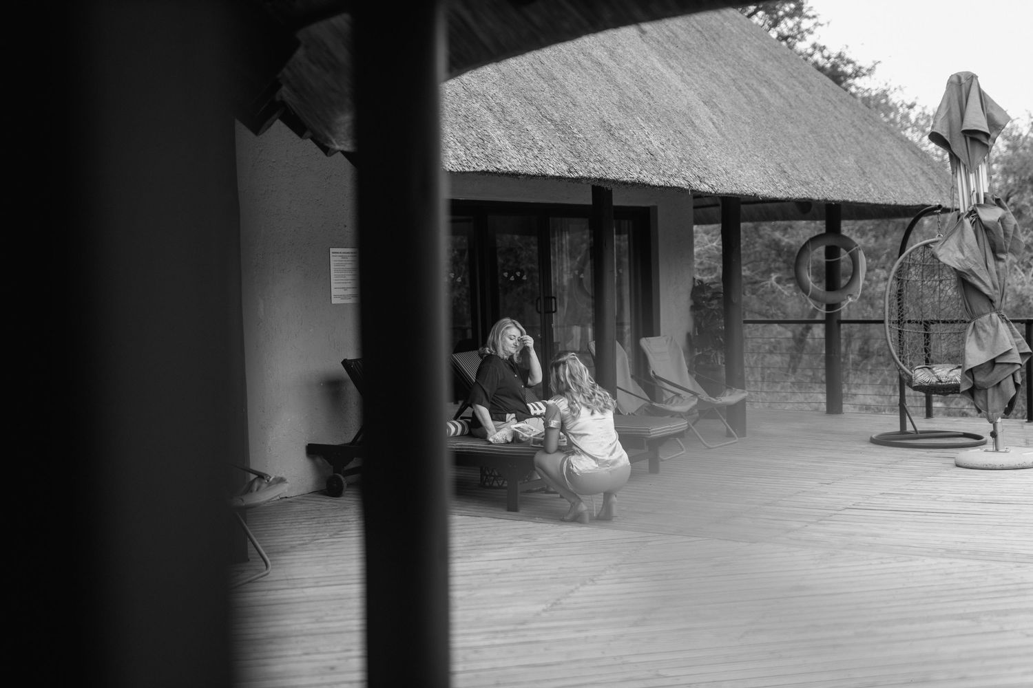 Black and white photo of covered porch at safari lodge.