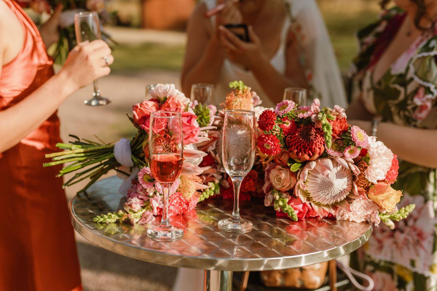 Romantic table setting with pink flowers and wine glasses for wedding reception.