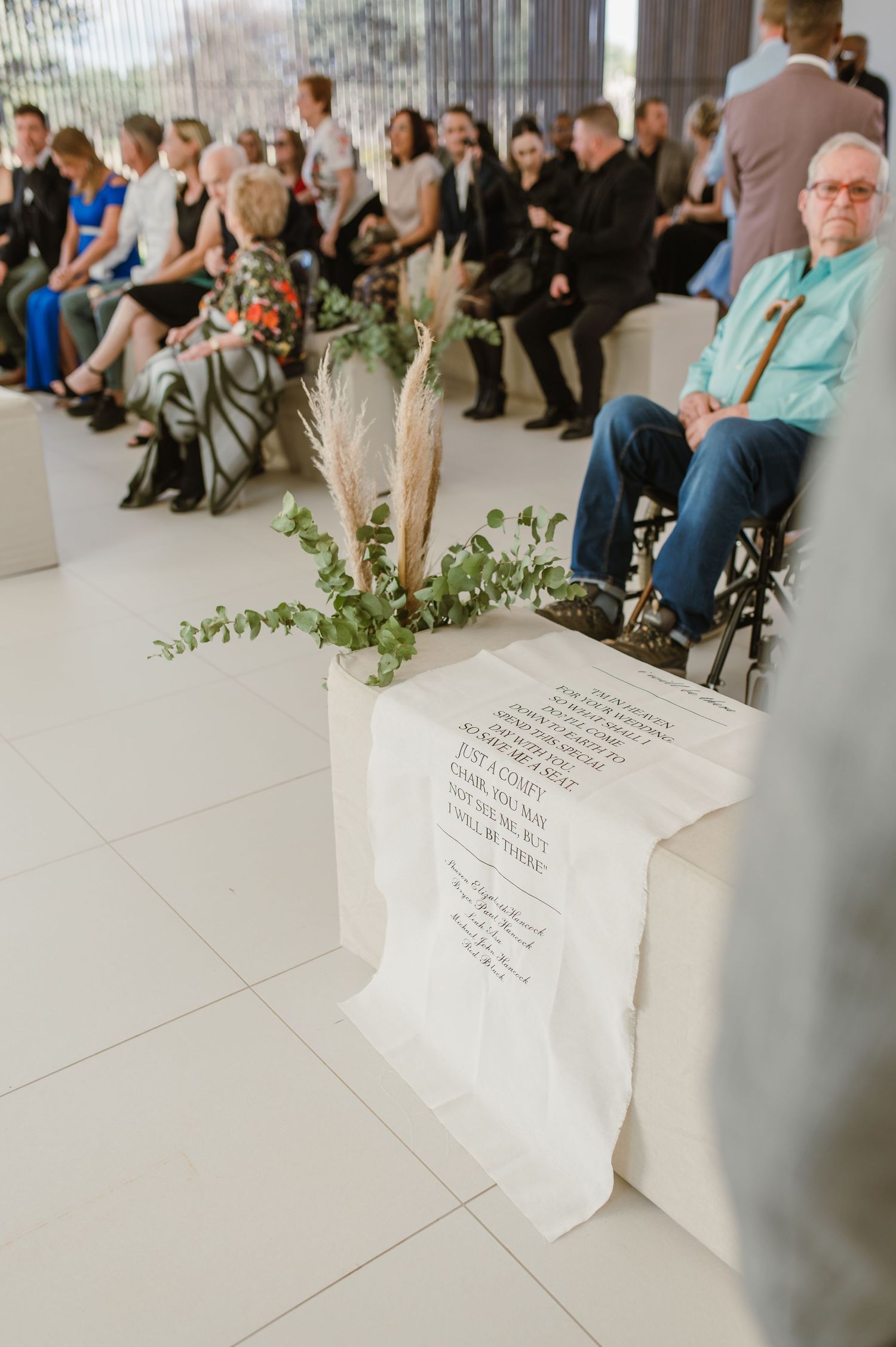Wedding ceremony seating arrangement with white floral decorations and paper details.