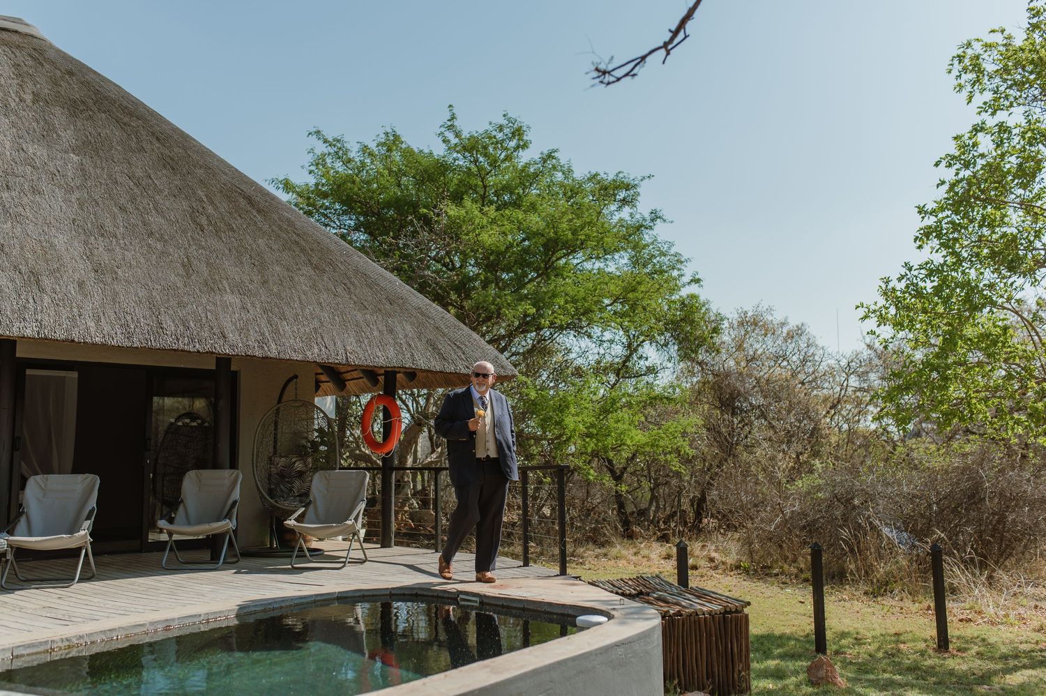 Thatched roof gazebo structure in a safari-style setting with natural surroundings.