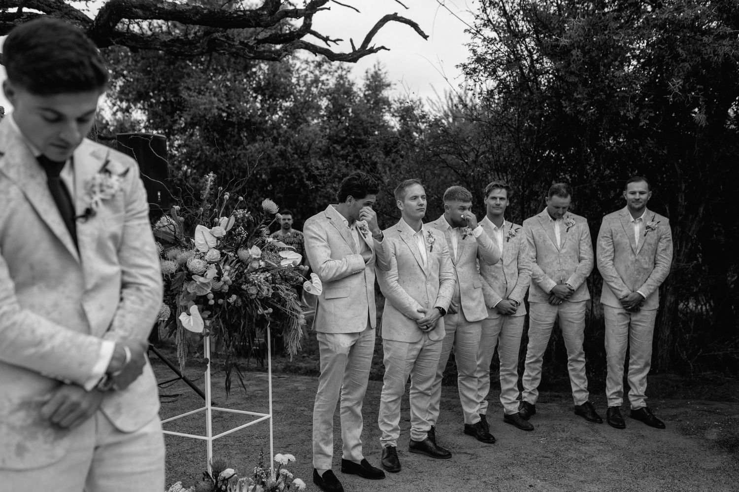 Black and white photo of wedding party members lined up outdoors.