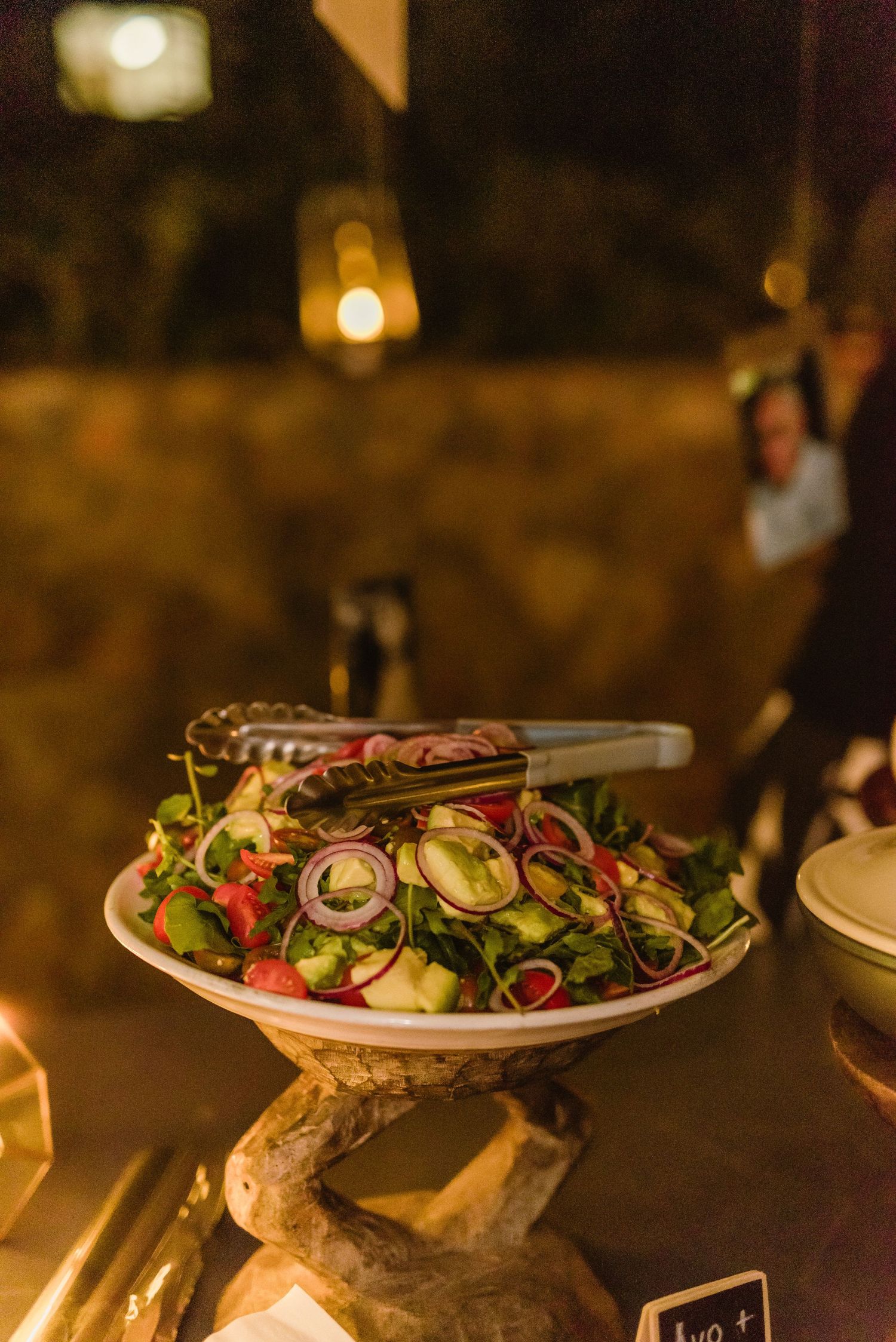 Fresh salads and appetizers displayed on elegant white plates at a catered event.