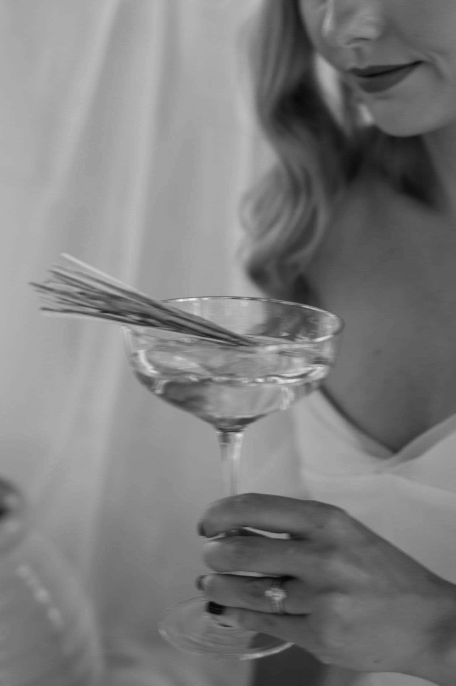 Close-up of a champagne glass with wheat stems in black and white photography.