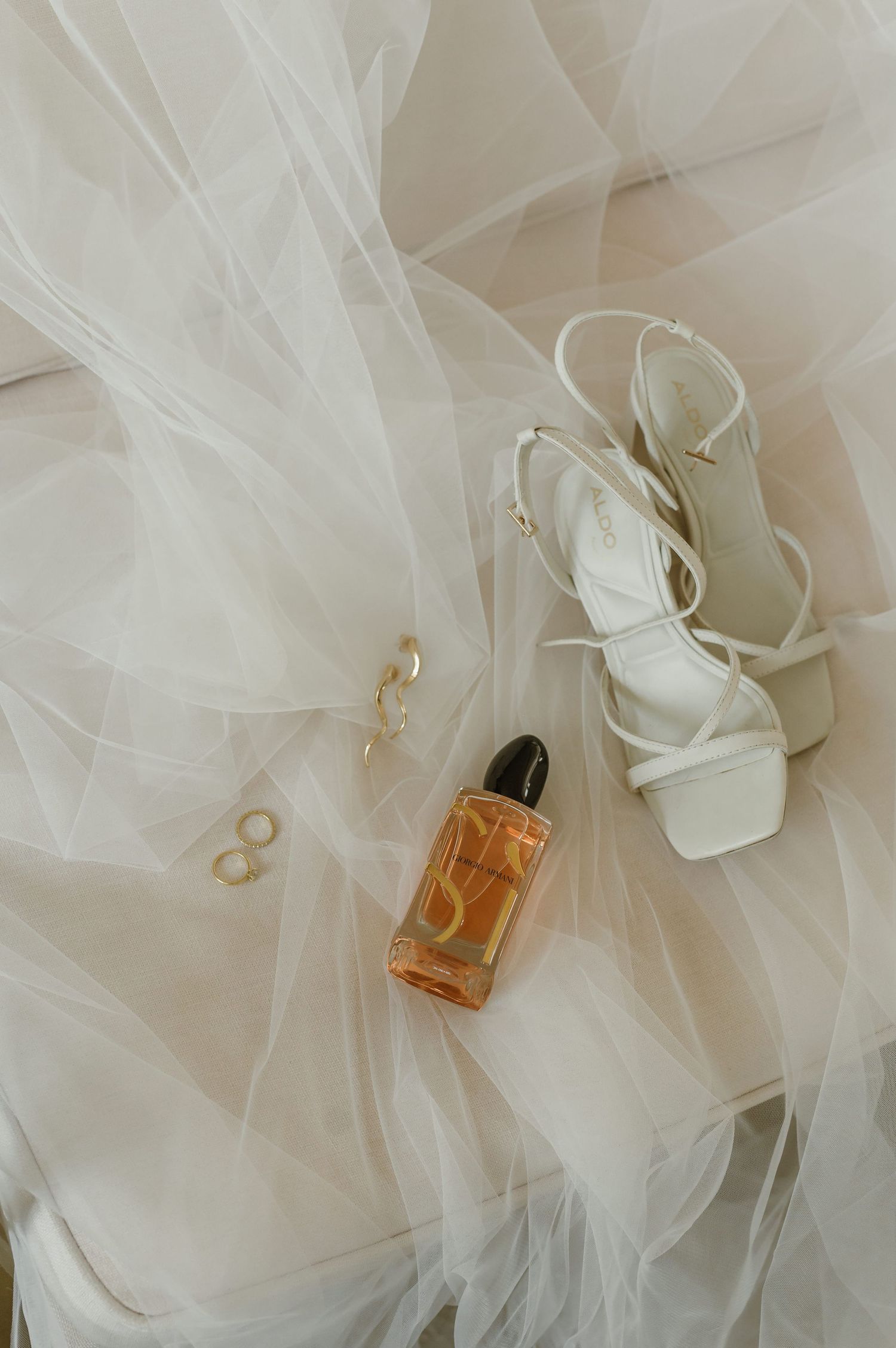 Perfume bottles nestled in delicate white tulle fabric creating an ethereal and luxurious composition.