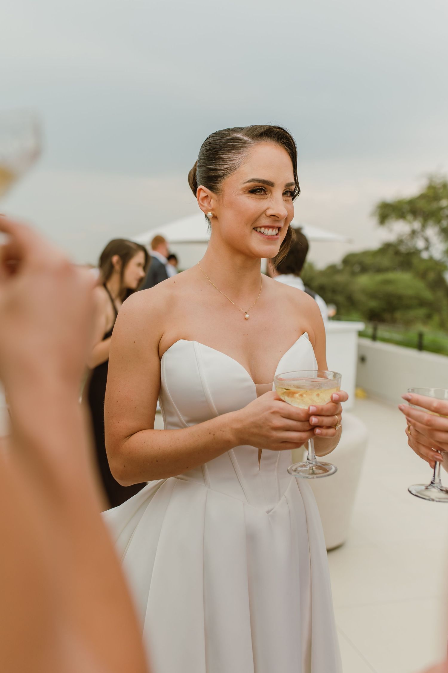 Wedding reception guest enjoying drinks and conversation at an outdoor celebration.