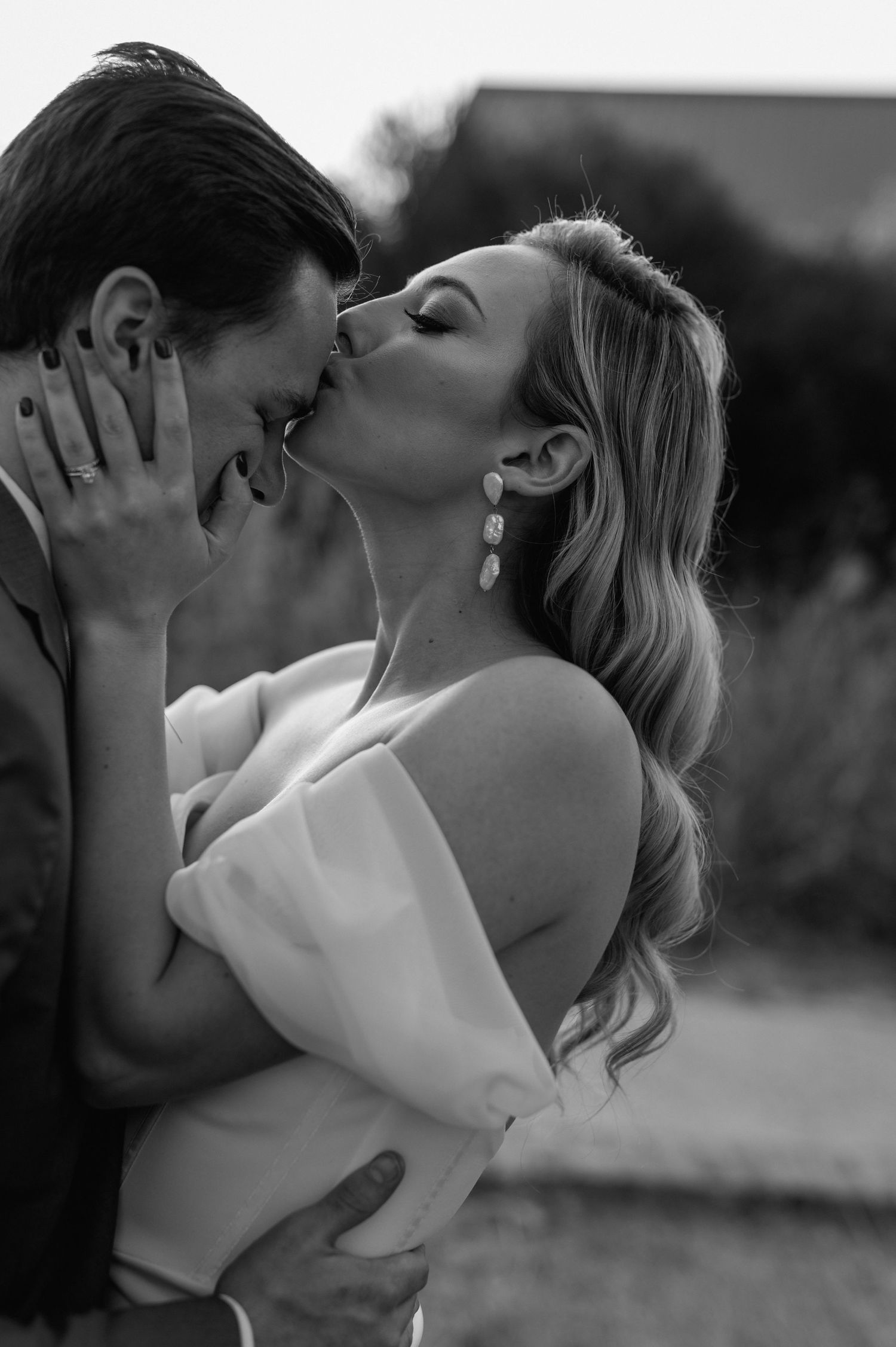Black and white portrait captures a tender embrace between newlyweds.