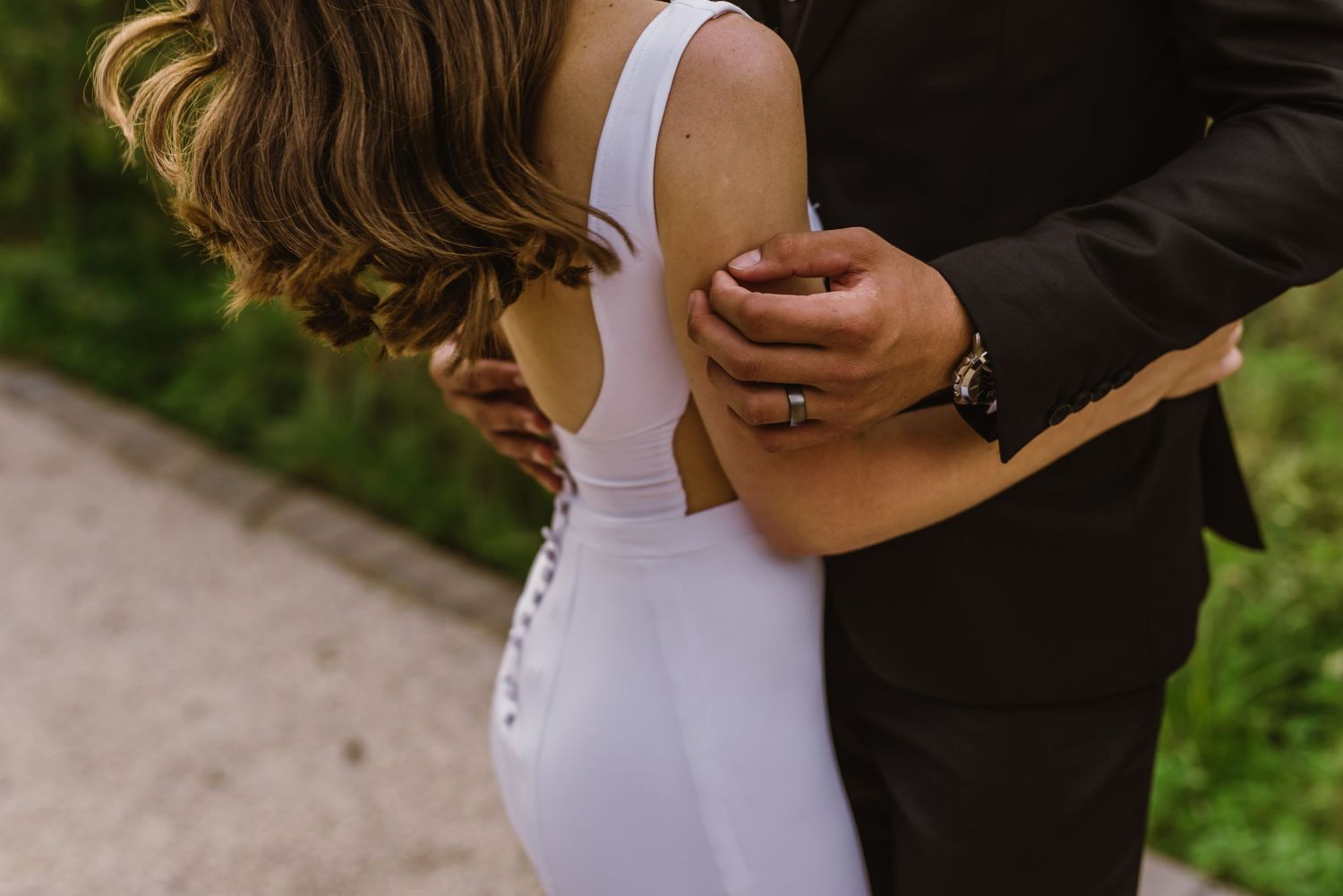 Couple in wedding attire sharing romantic moments outdoors.