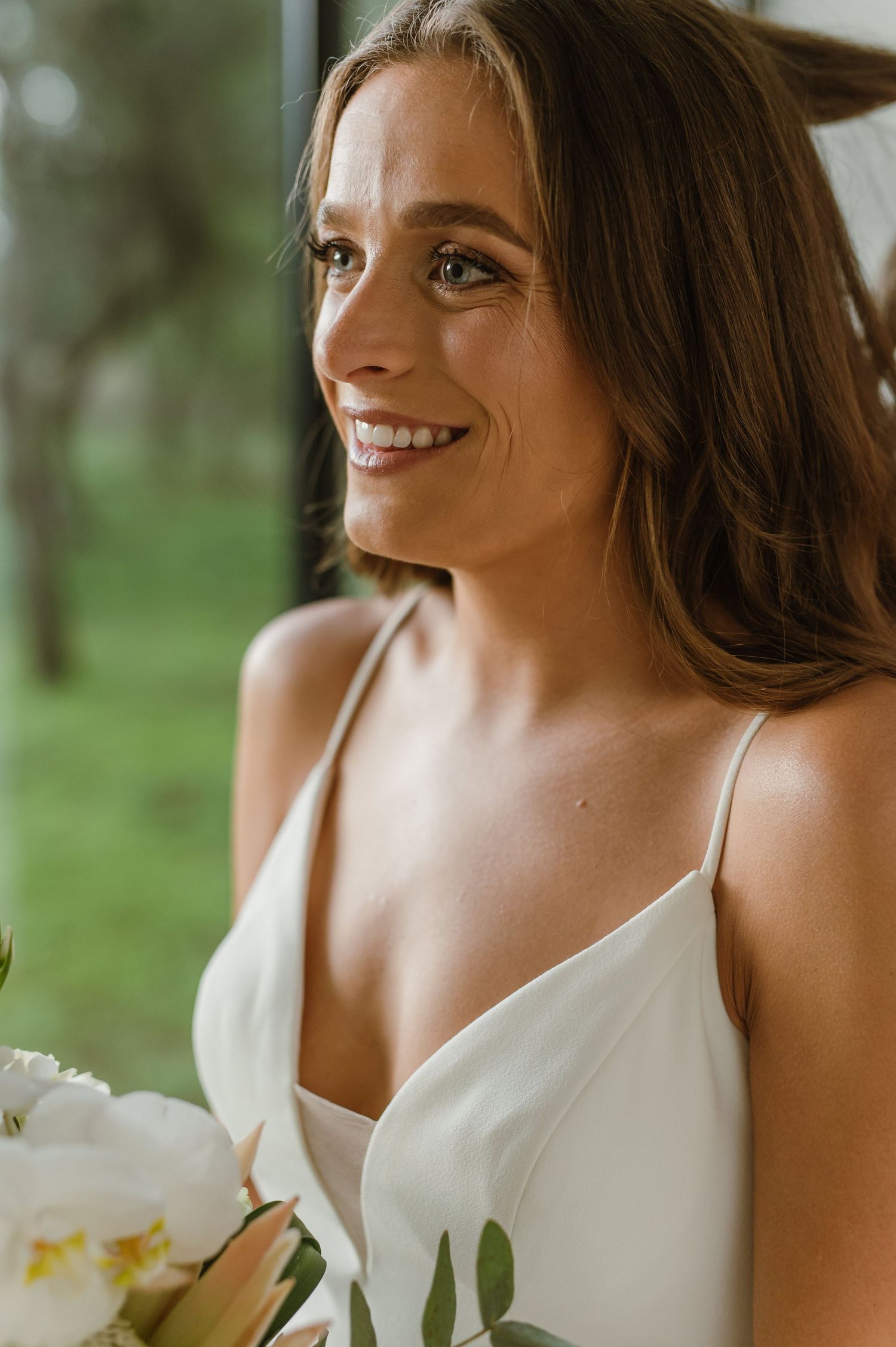 Close-up bridal portraits showing elegant white dress and natural makeup in an outdoor setting.