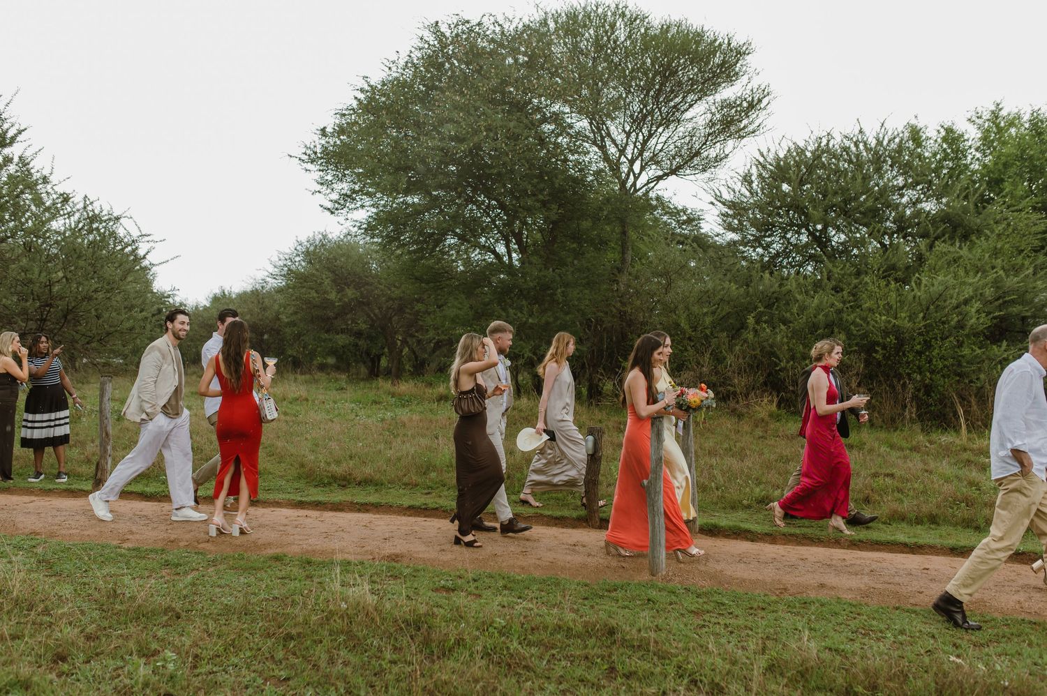 Wedding party and guests walking through a scenic outdoor venue.