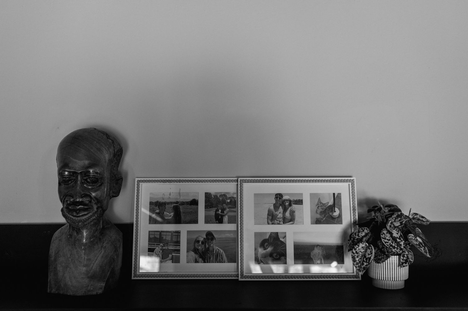 Black and white shelf display with framed photos and decorative items.