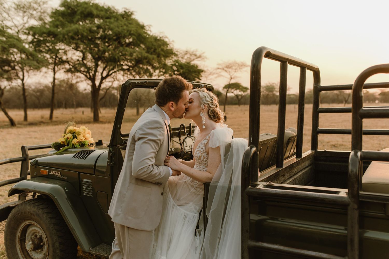 Wedding celebration on a sunlit outdoor terrace with flowing white dress and grey suit.