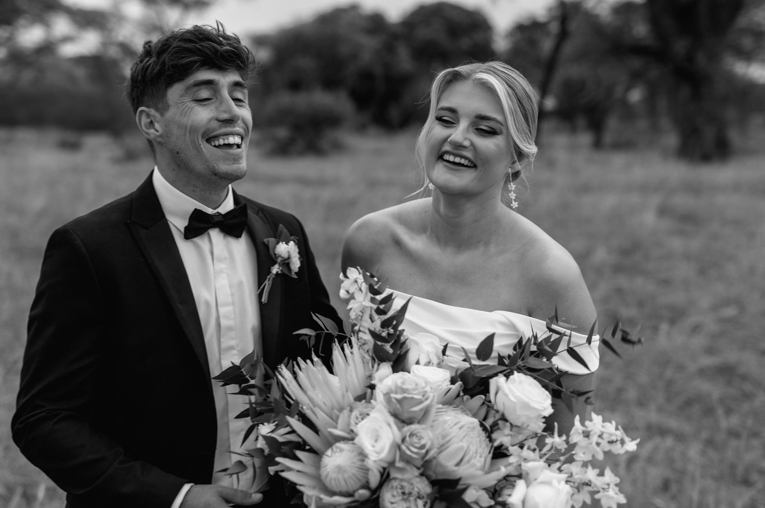 Black and white wedding portrait capturing joyful moment between newlyweds.