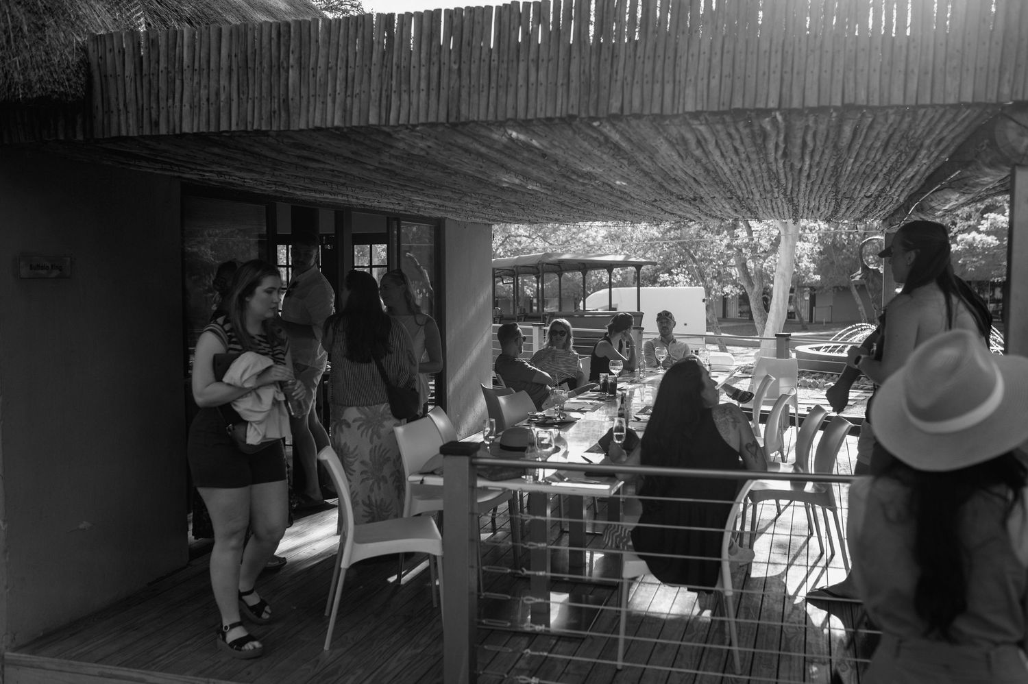 Silhouettes of people gathering under a covered outdoor space.