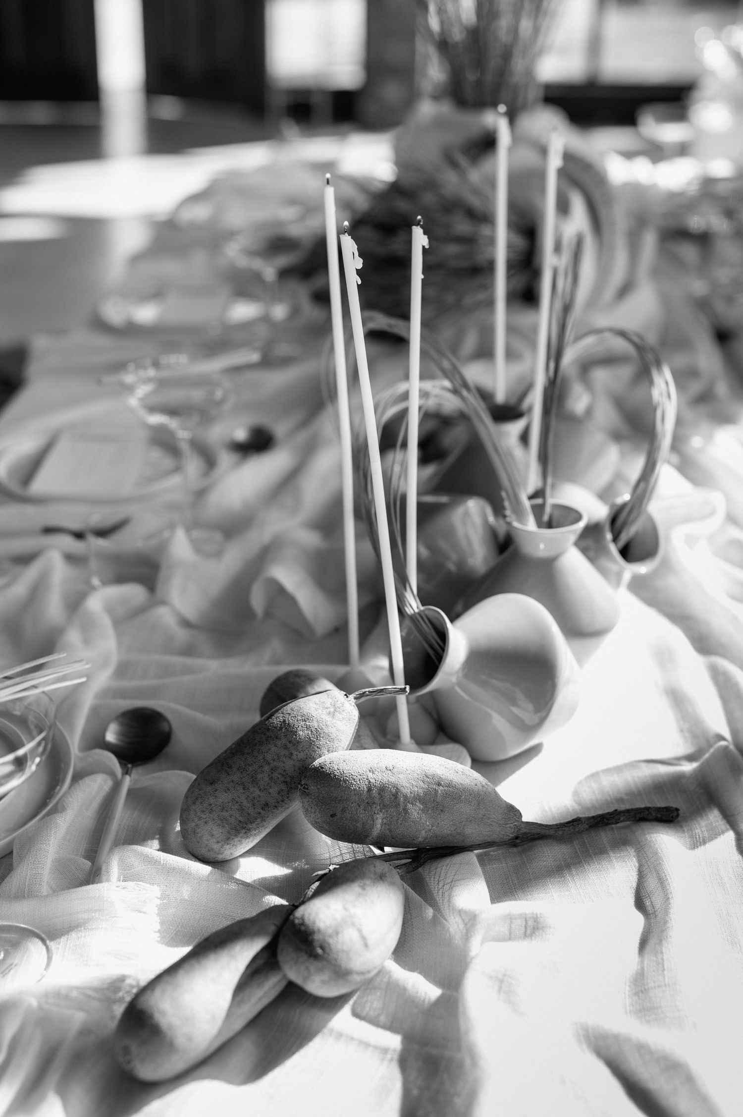 Black and white detail shot of wedding table decor with candles and stones.
