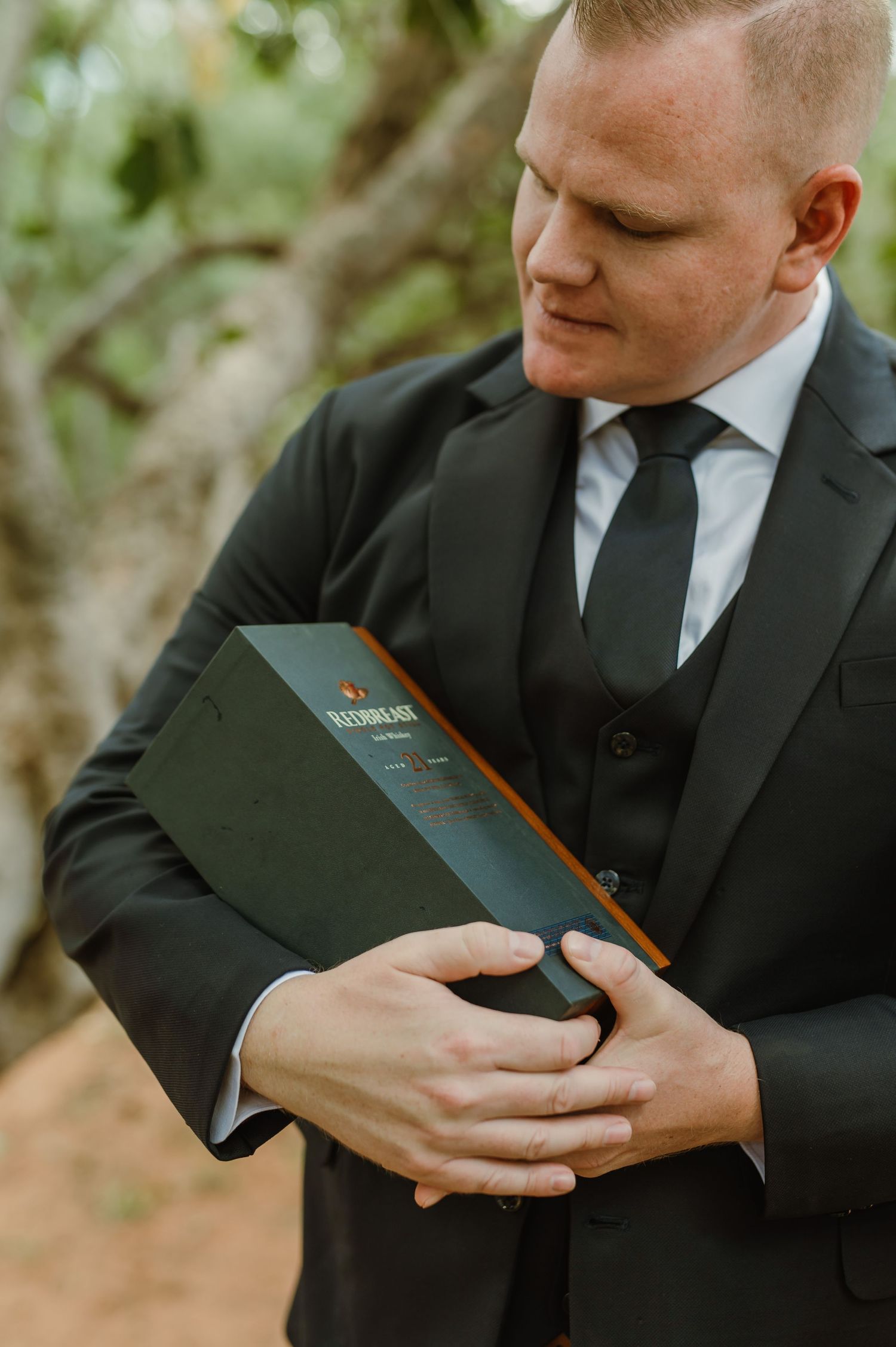 Close-up shots of hands holding a black book in formal wedding attire.