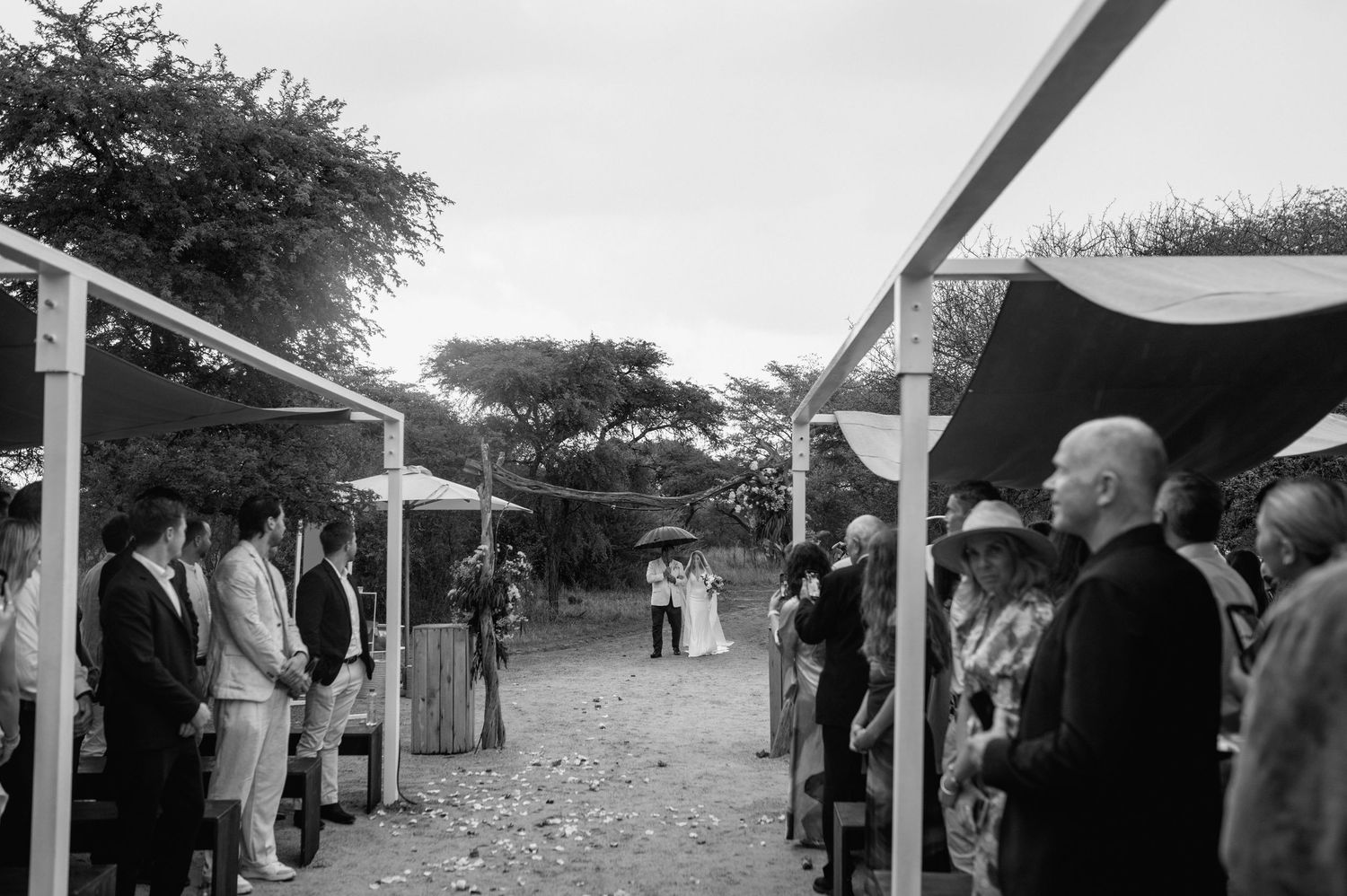 White tent canopies set up for an outdoor wedding reception on a rural property.