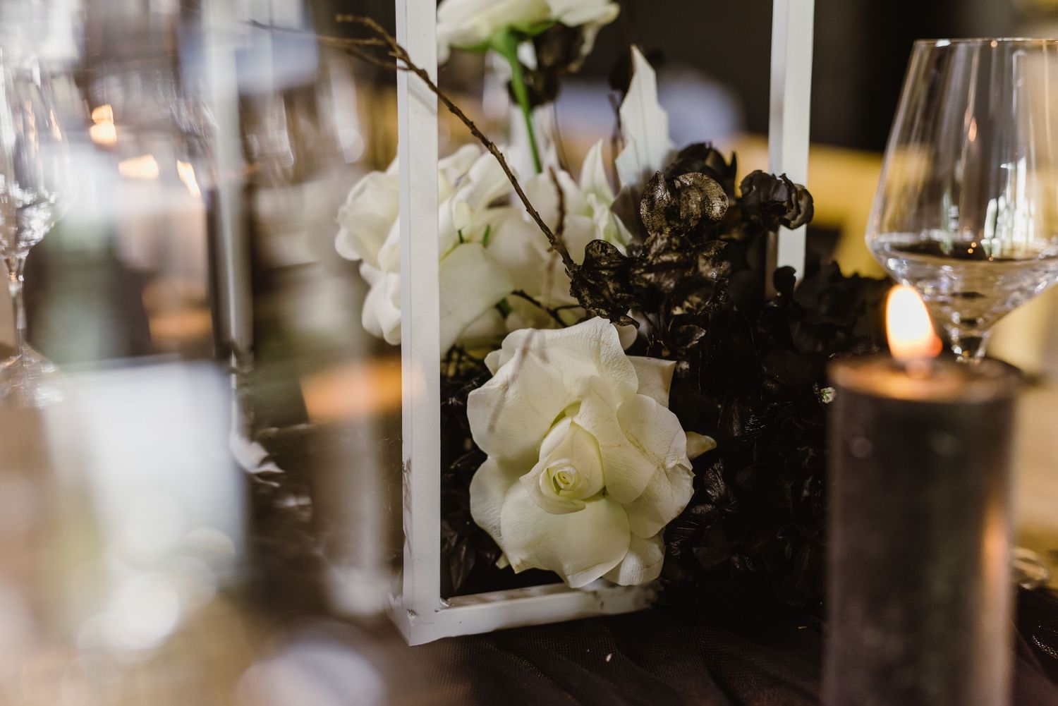 Close-up of modern white geometric wedding table decorations with candlelight.
