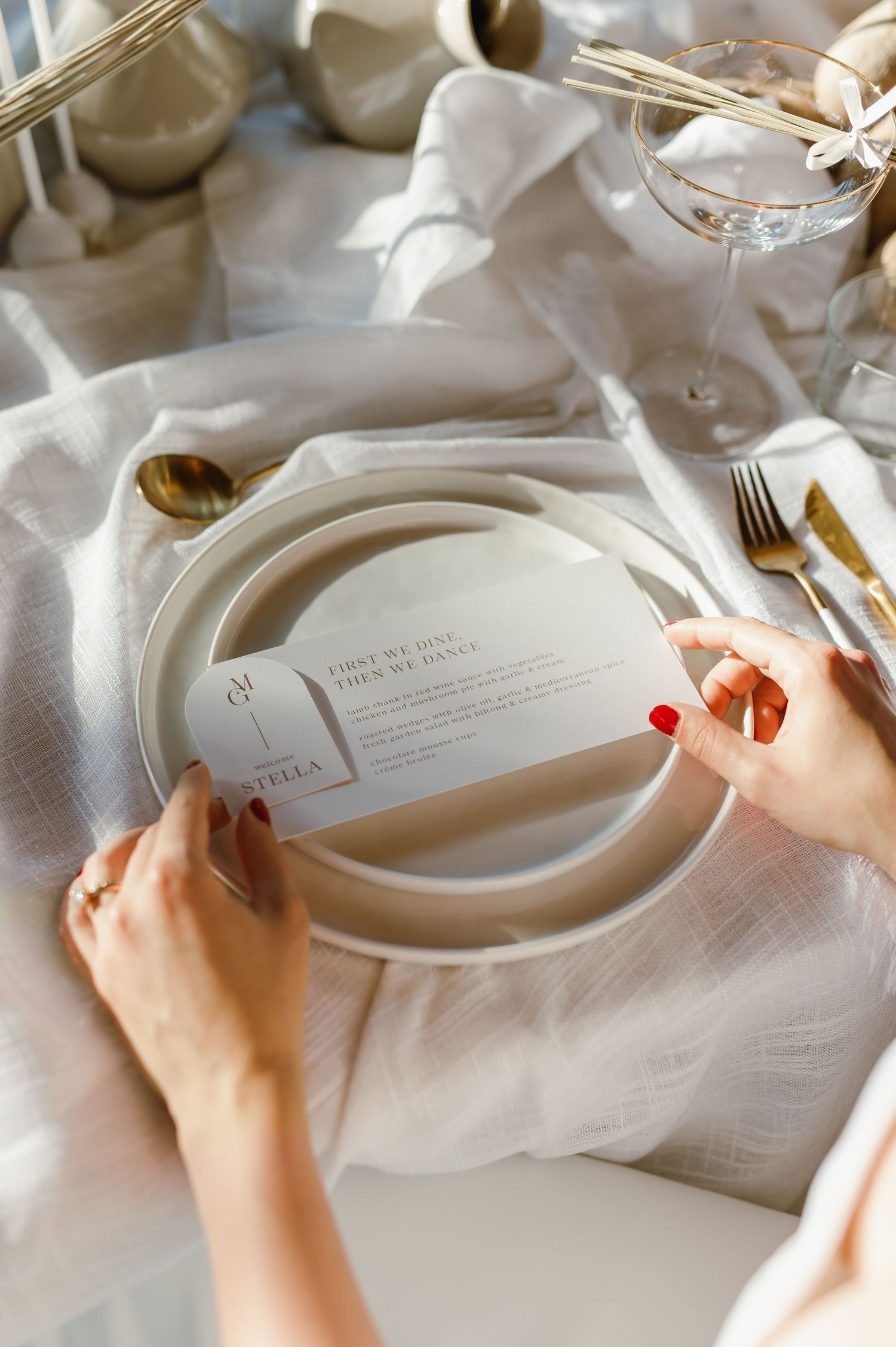 Elegant place setting with menu card and silverware on white linen tablecloth.