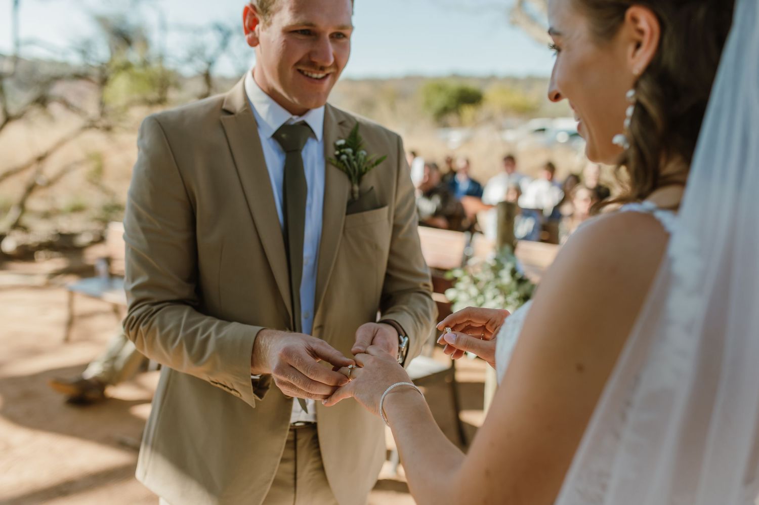 A couple shares a joyful moment during their outdoor desert wedding ceremony.