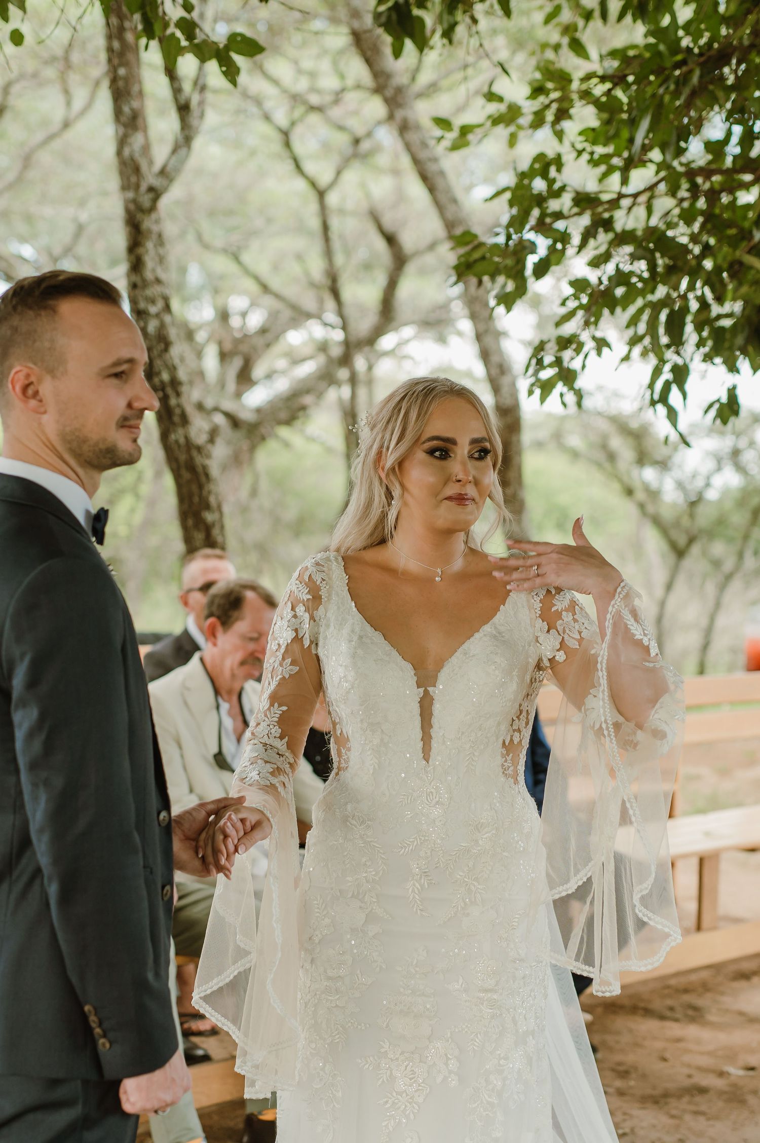 Elegant outdoor wedding ceremony with lace details and natural lighting.