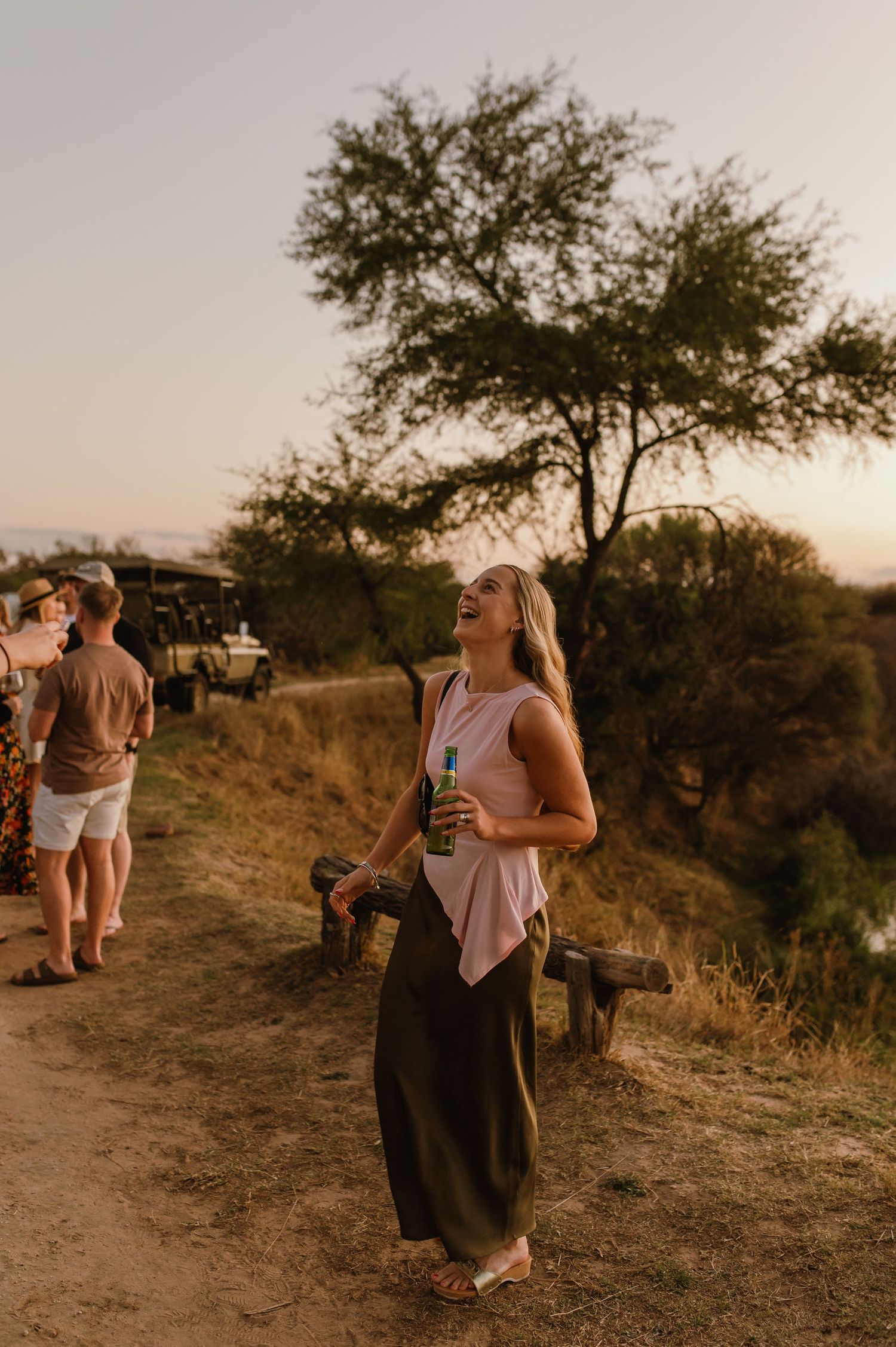 Casual gathering of people on a grassy hill during golden hour.