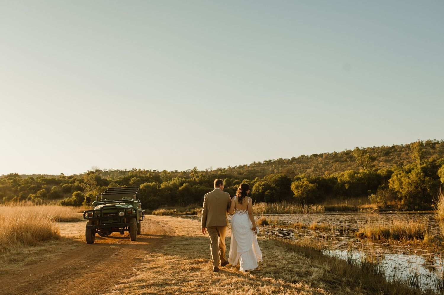 Panoramic view of a wedding photoshoot in a rural setting with mountains in the distance.