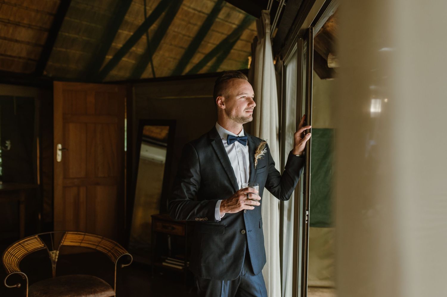 Elegant wedding attire details with a bow tie and white shirt in natural lighting.