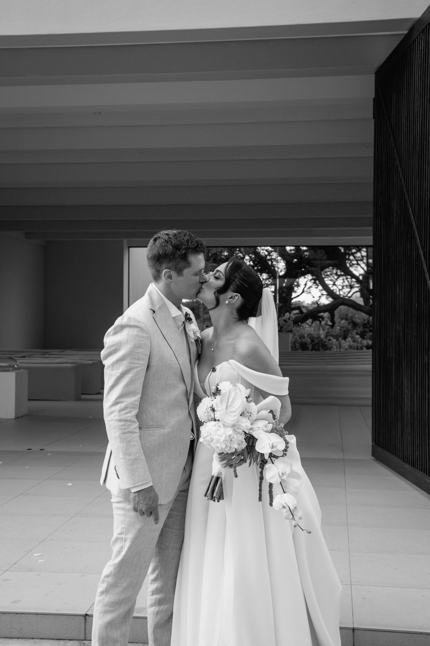 A couple shares an intimate moment during their wedding in a contemporary minimalist setting.