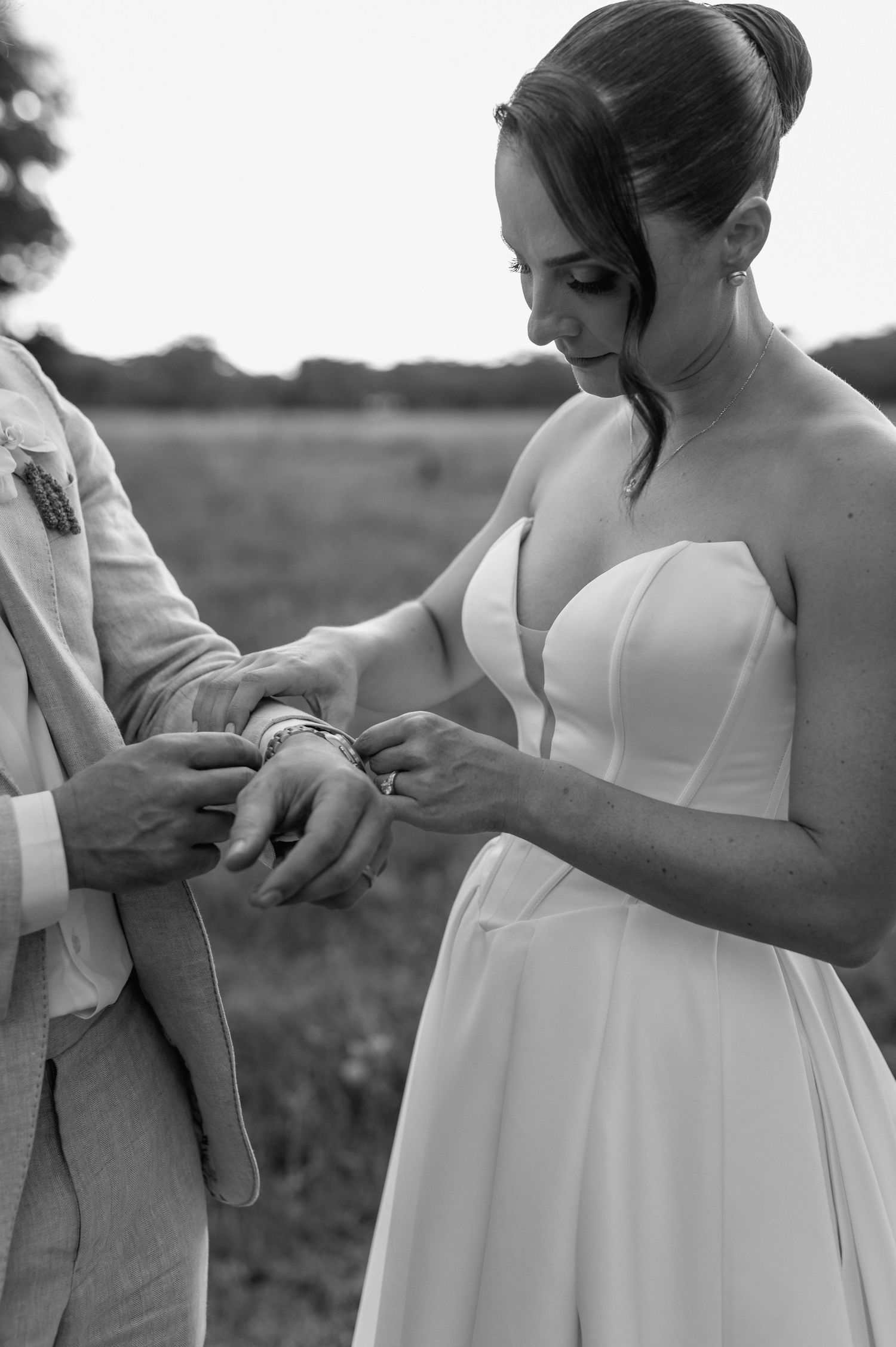 Black and white wedding photos showing couple exchanging rings in a natural outdoor setting.
