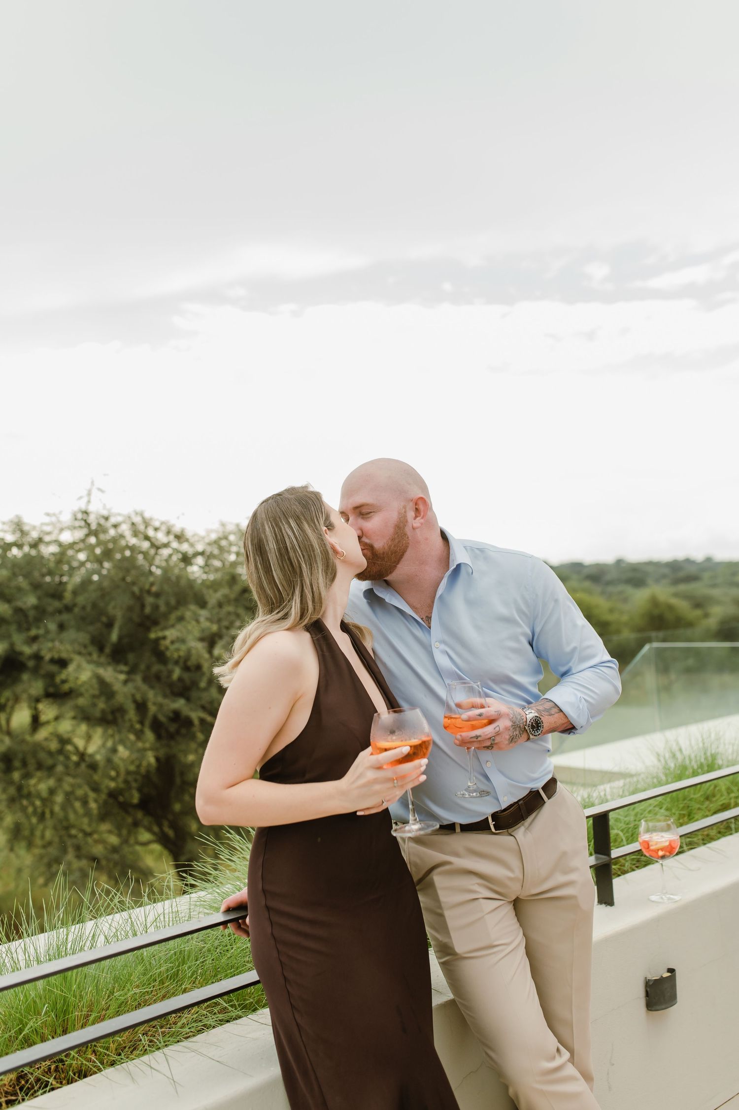 Romantic moment shared on an outdoor terrace with drinks at sunset.