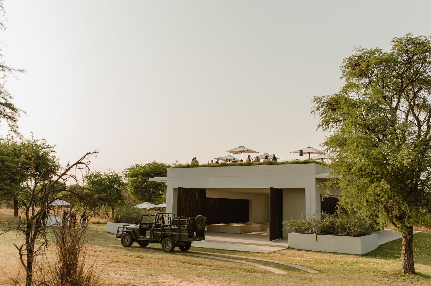 Wide landscape view of a modern venue with trees and buildings in the background.