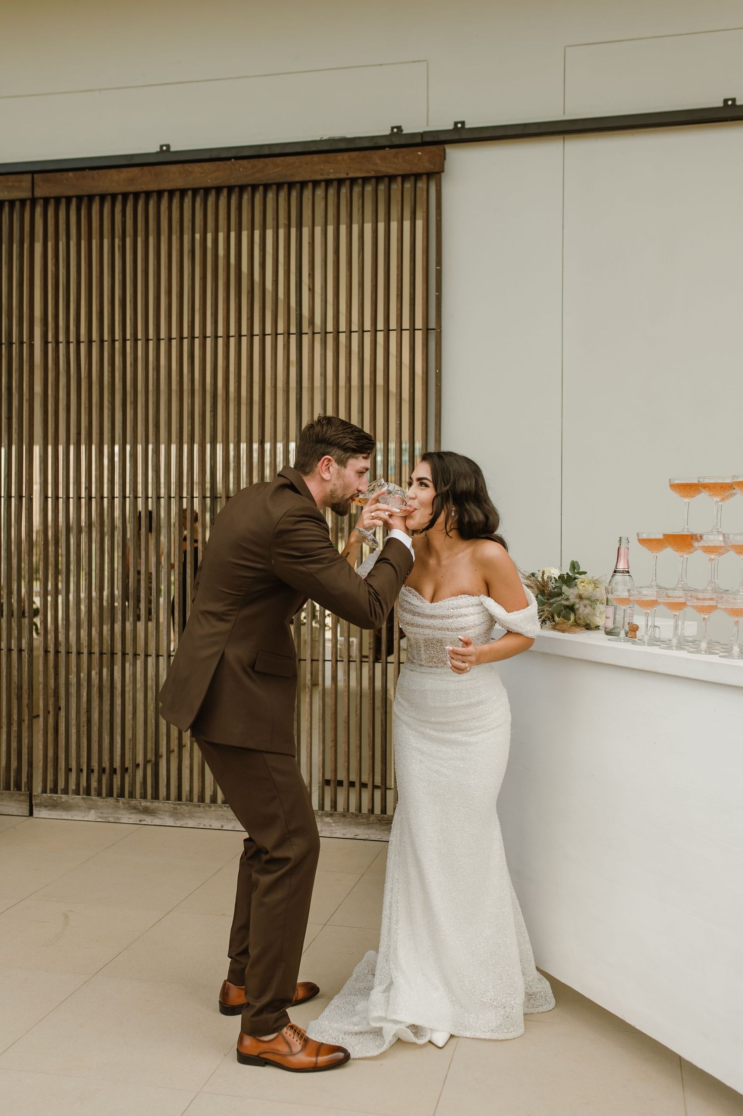 Sequence showing couple pouring champagne into a tower of glasses at their wedding reception.