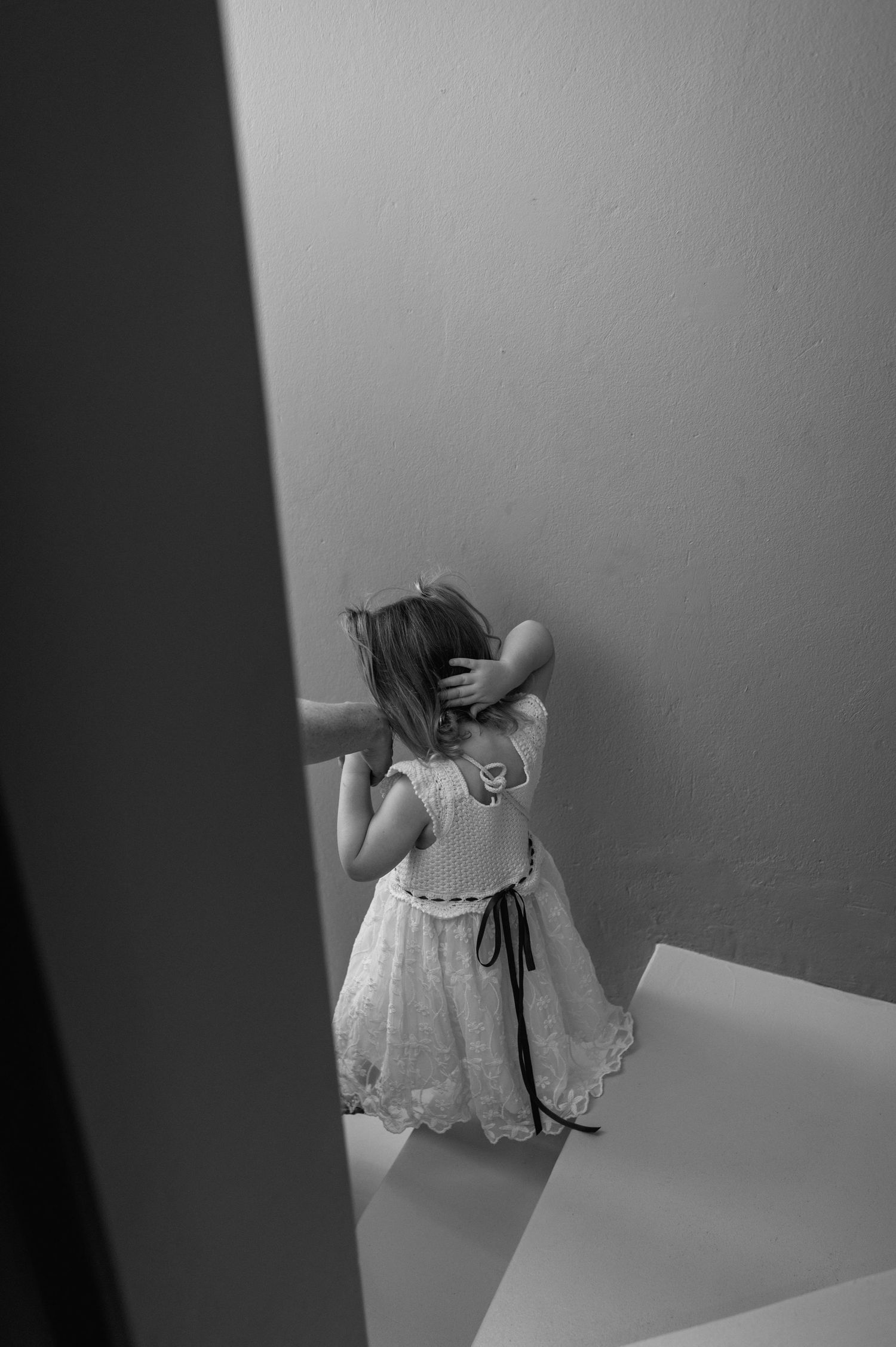 Black and white artistic photo of a young child playing on stairs.