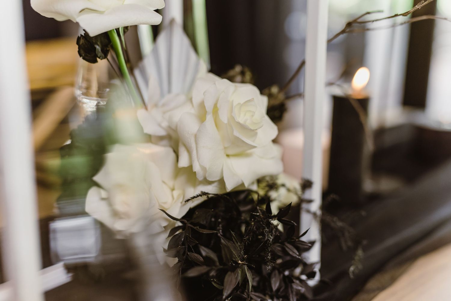 White roses and modern geometric decor create elegant wedding table centerpieces.