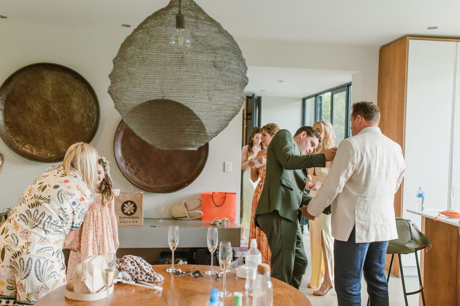 People gather in a modern interior space with decorative circular wall hangings.