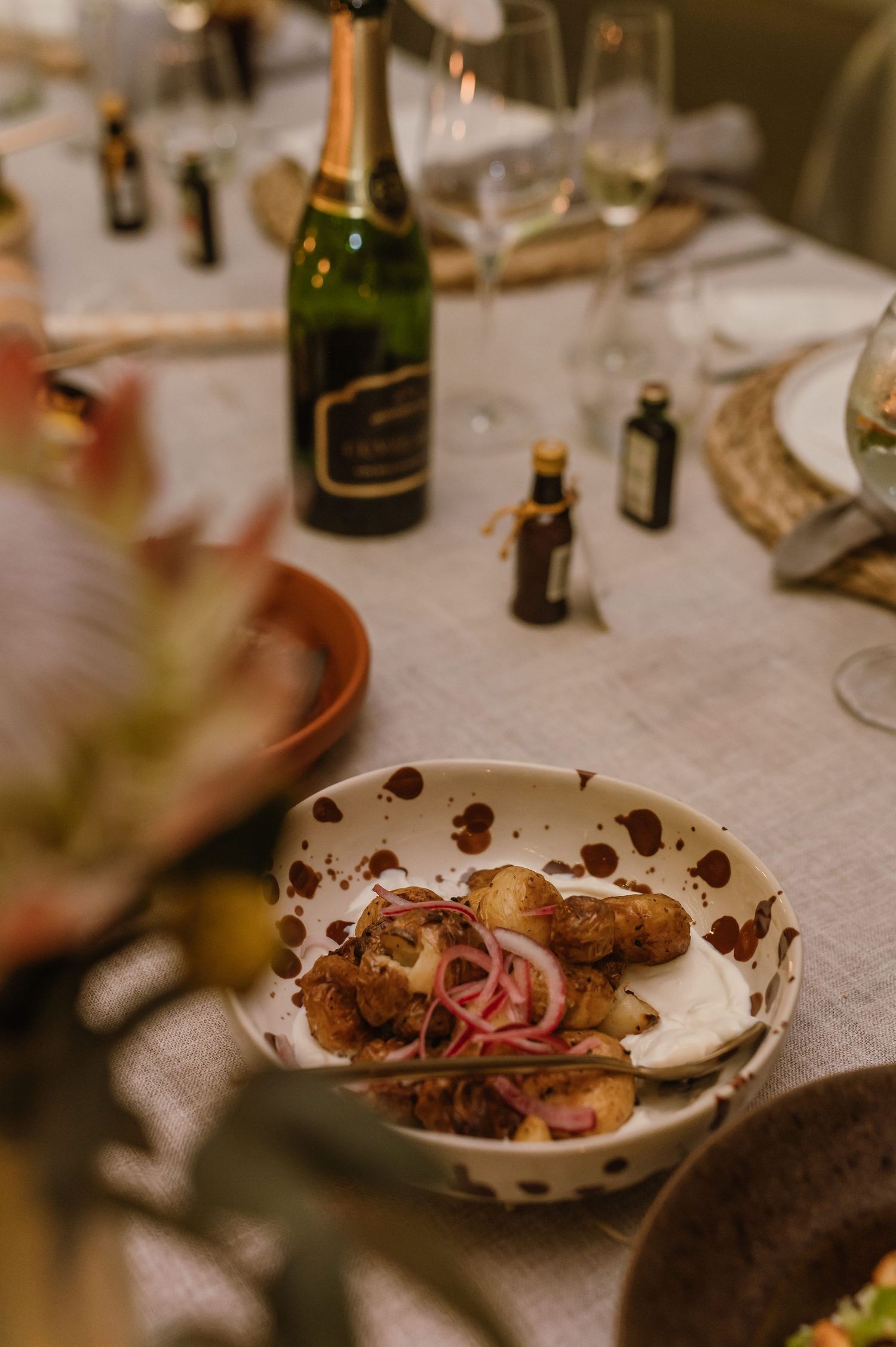 Close-up of partially eaten plates of food on an elegant table setting at a wedding reception.