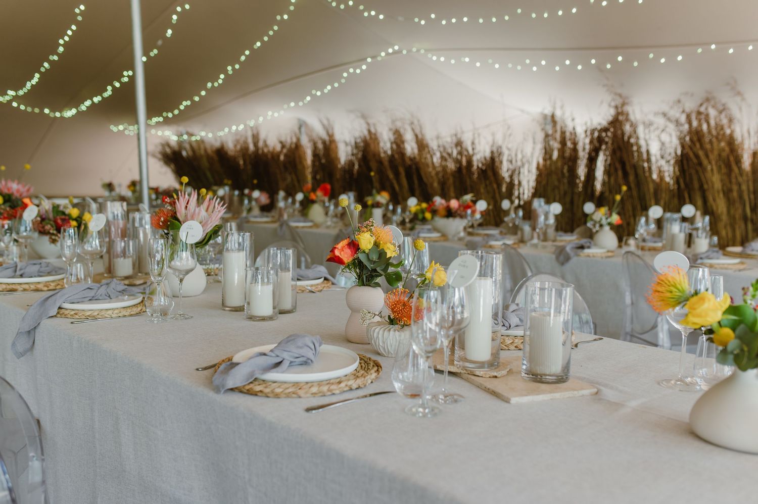 Elegant wedding table settings with floral centerpieces and dried pampas grass decorations.