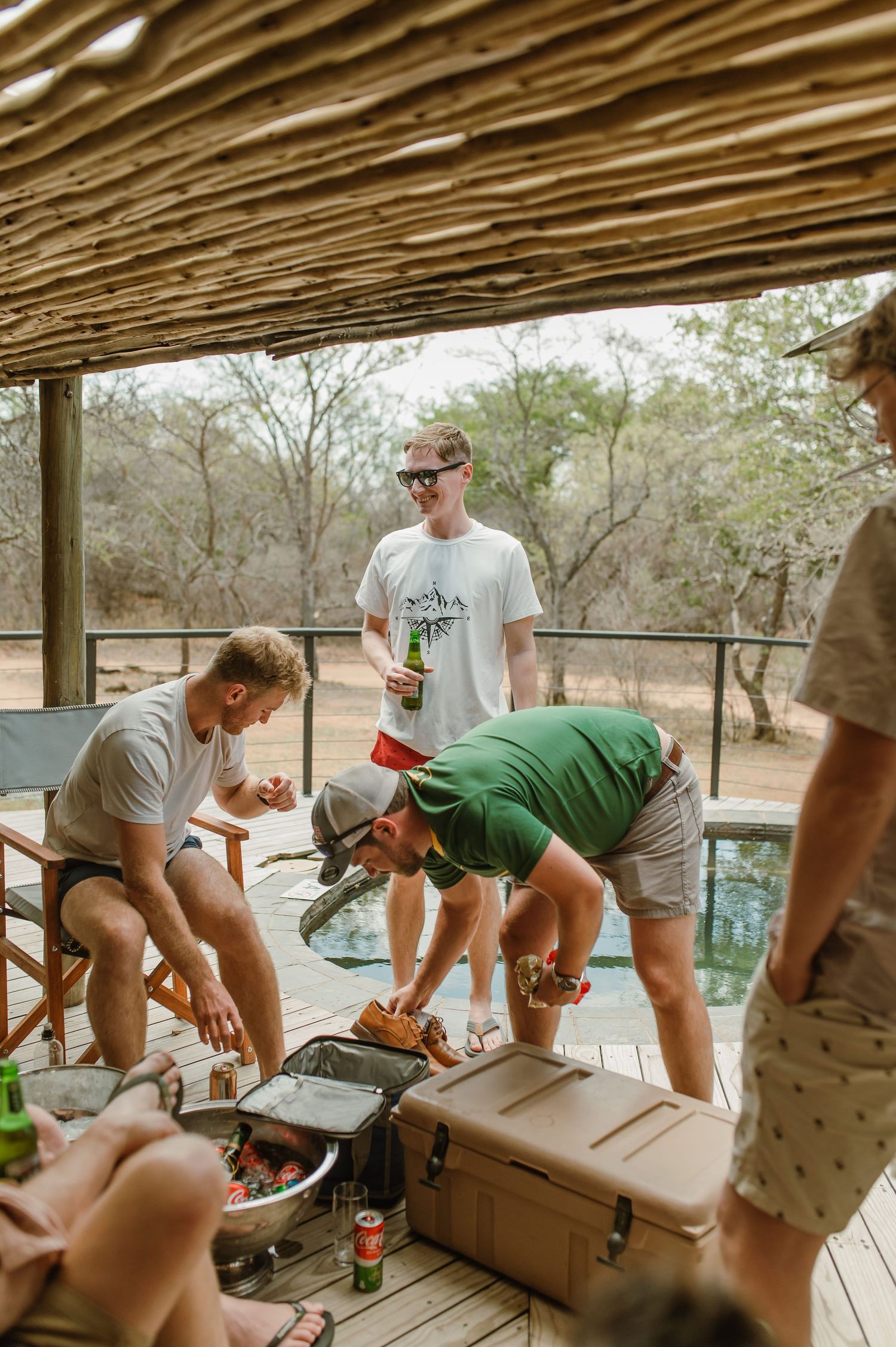 People gathered around tables on a covered outdoor deck.