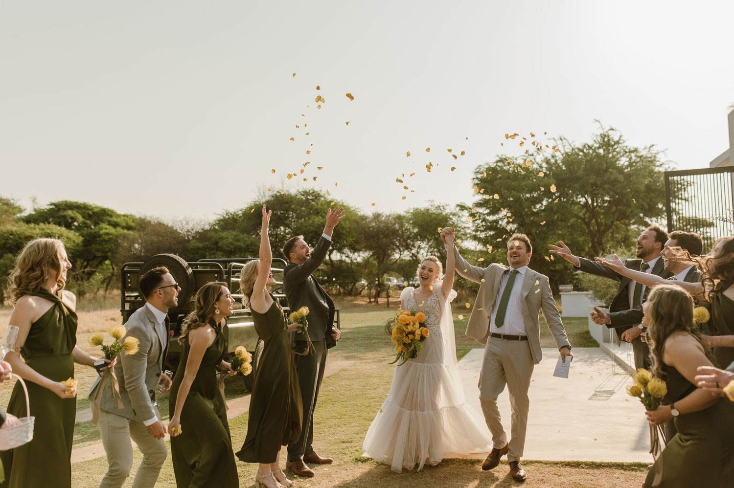 Wedding guests throwing confetti during outdoor celebration exit.